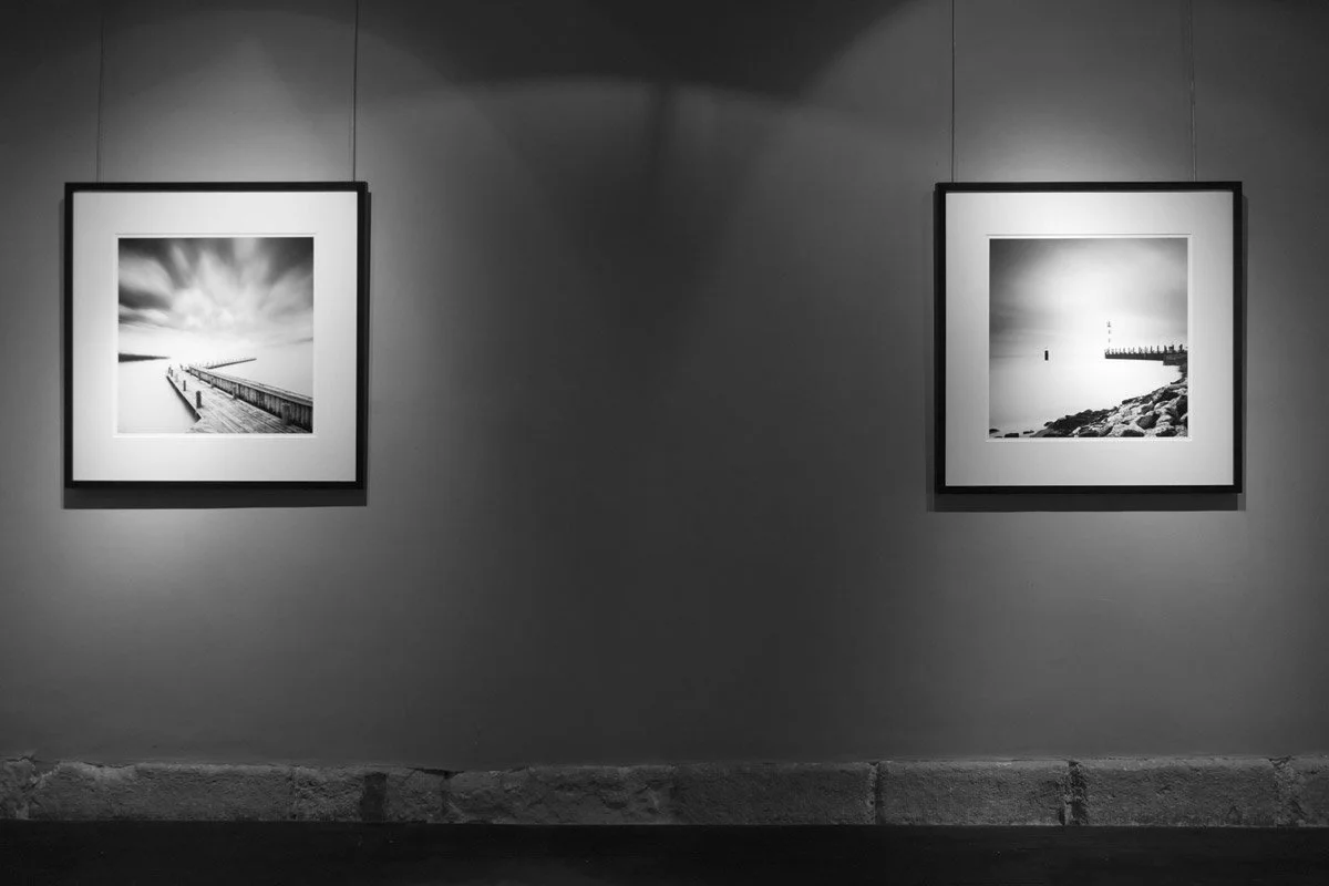 Two framed black-and-white long-exposure seascape photographs by Gerald Berghammer displayed at Galerie Arnoux in Paris during the 2017 exhibition.