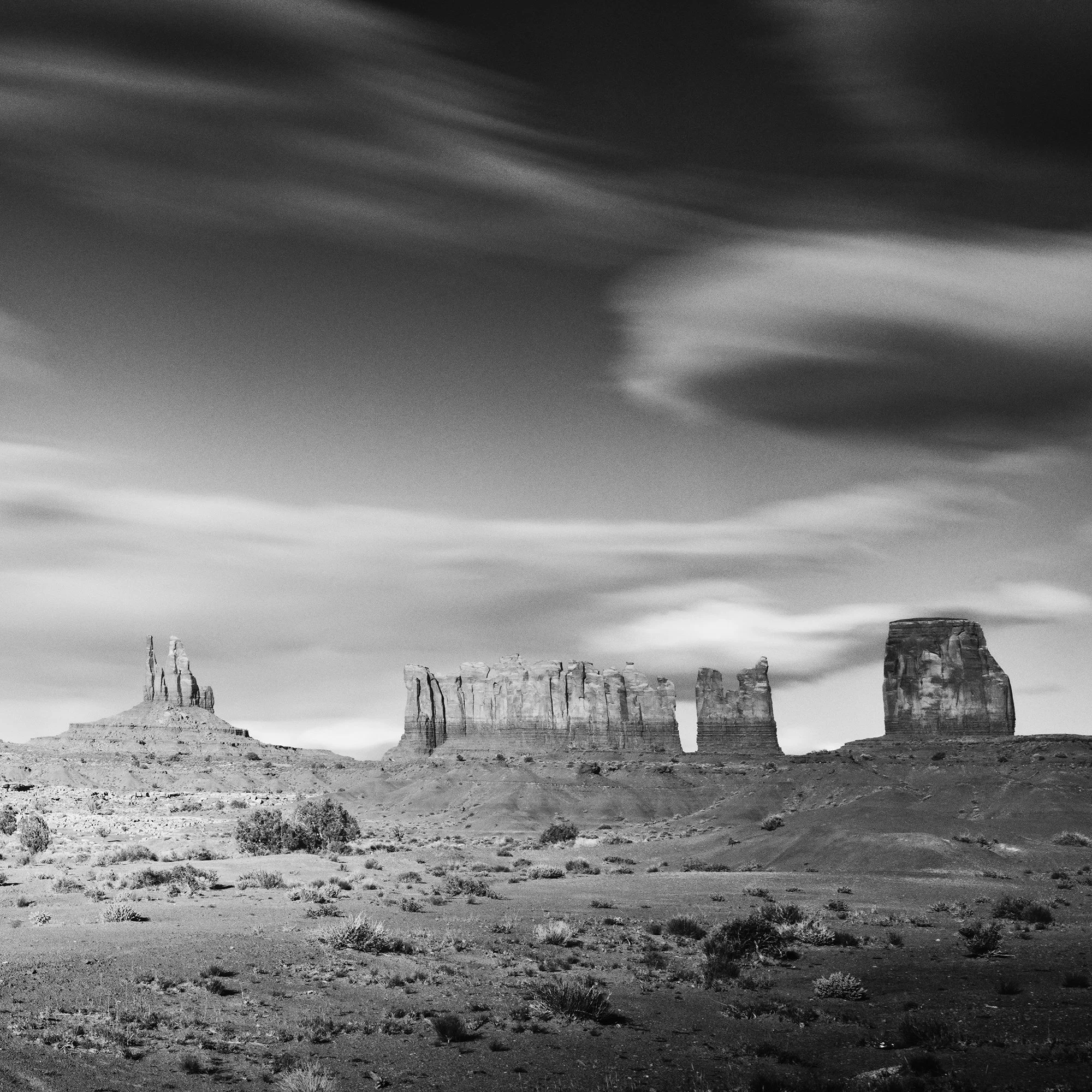 © 2015 Gerald Berghammer - Black and white photography. Landscape of rugged desert terrain with large rock formations and scattered vegetation under a cloudy sky. Print detail 2