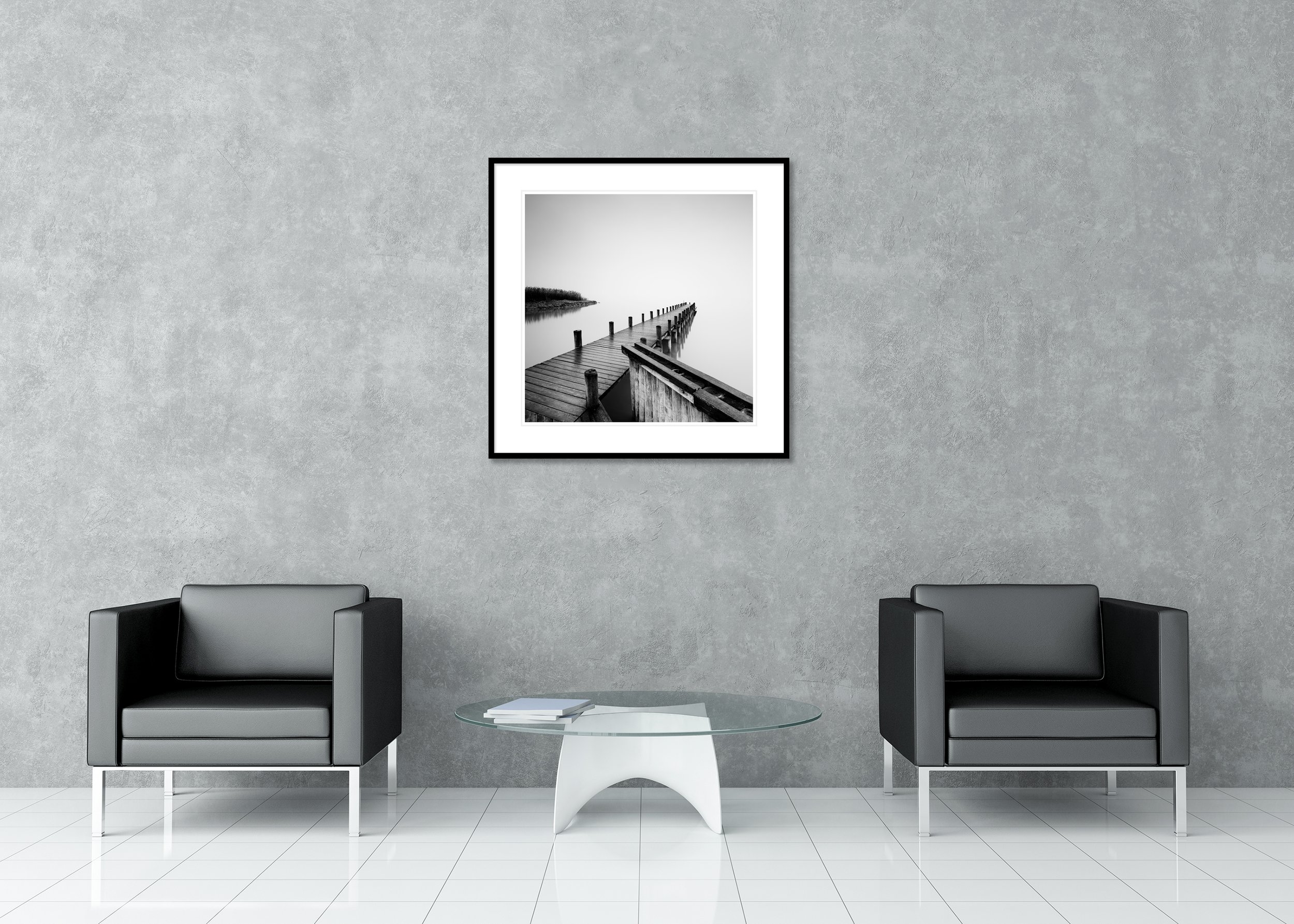 Wooden pier extending into a calm misty lake, black-and-white photo with shoreline reeds, archival pigment print in a classic frame with mount