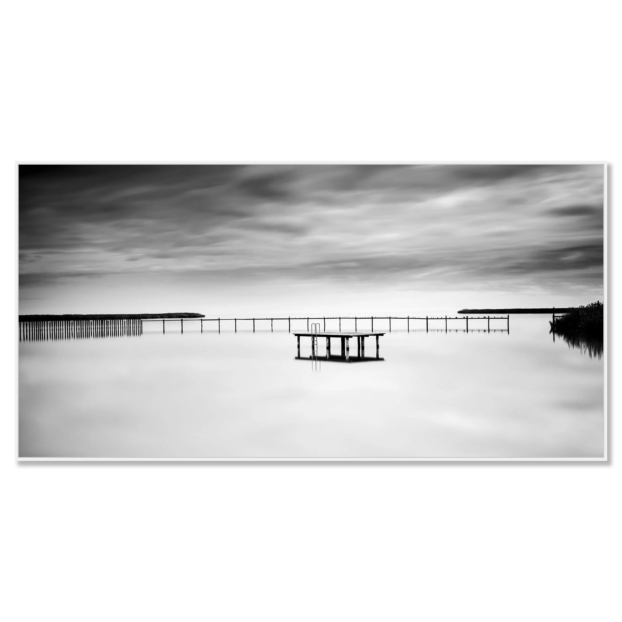 © 2023 Gerald Berghammer - Black and white minimalist waterscape. A calm body of water with a floating dock and a pier in the background, under a cloudy sky. Chromaluxe framed white