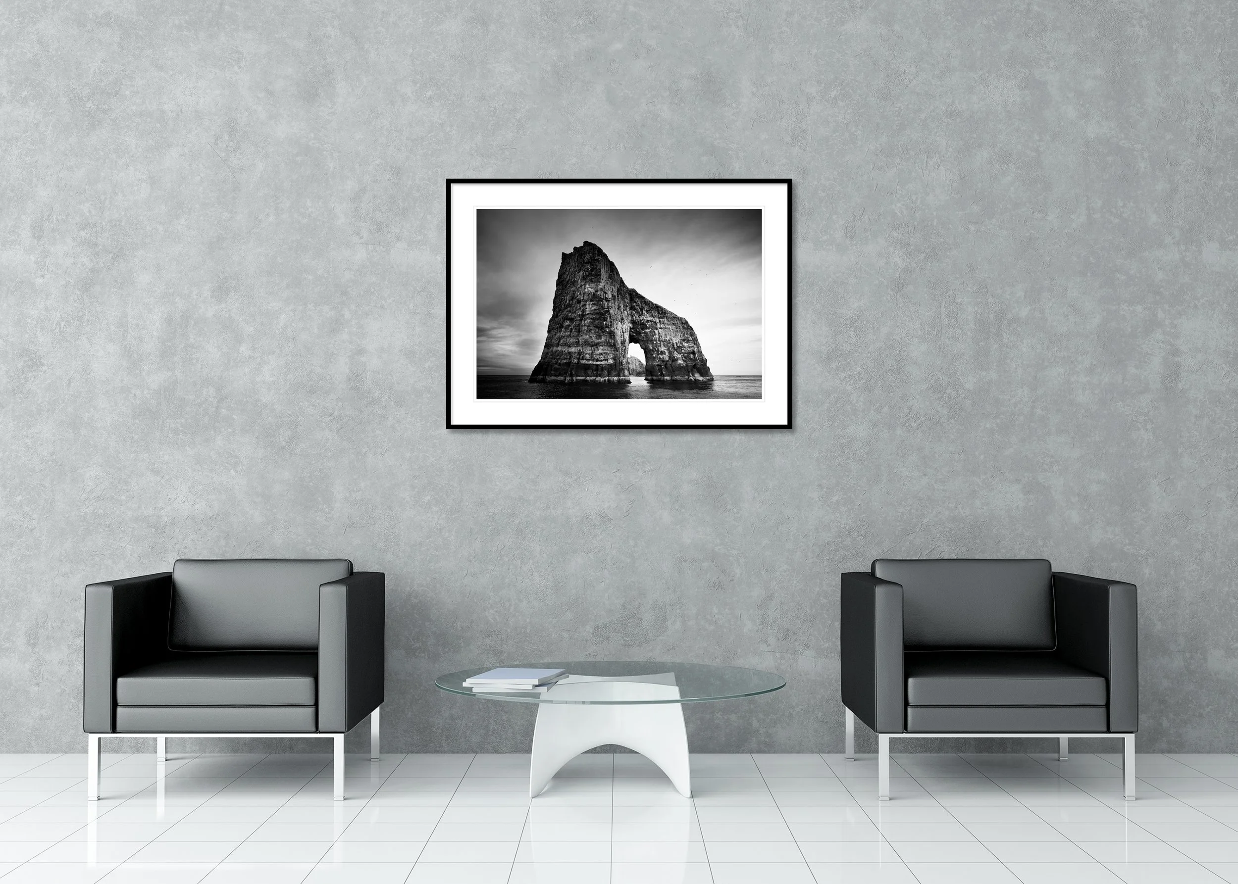 Monochrome seascape of a dramatic rock arch rising from the ocean, archival pigment print in a classic frame with mount