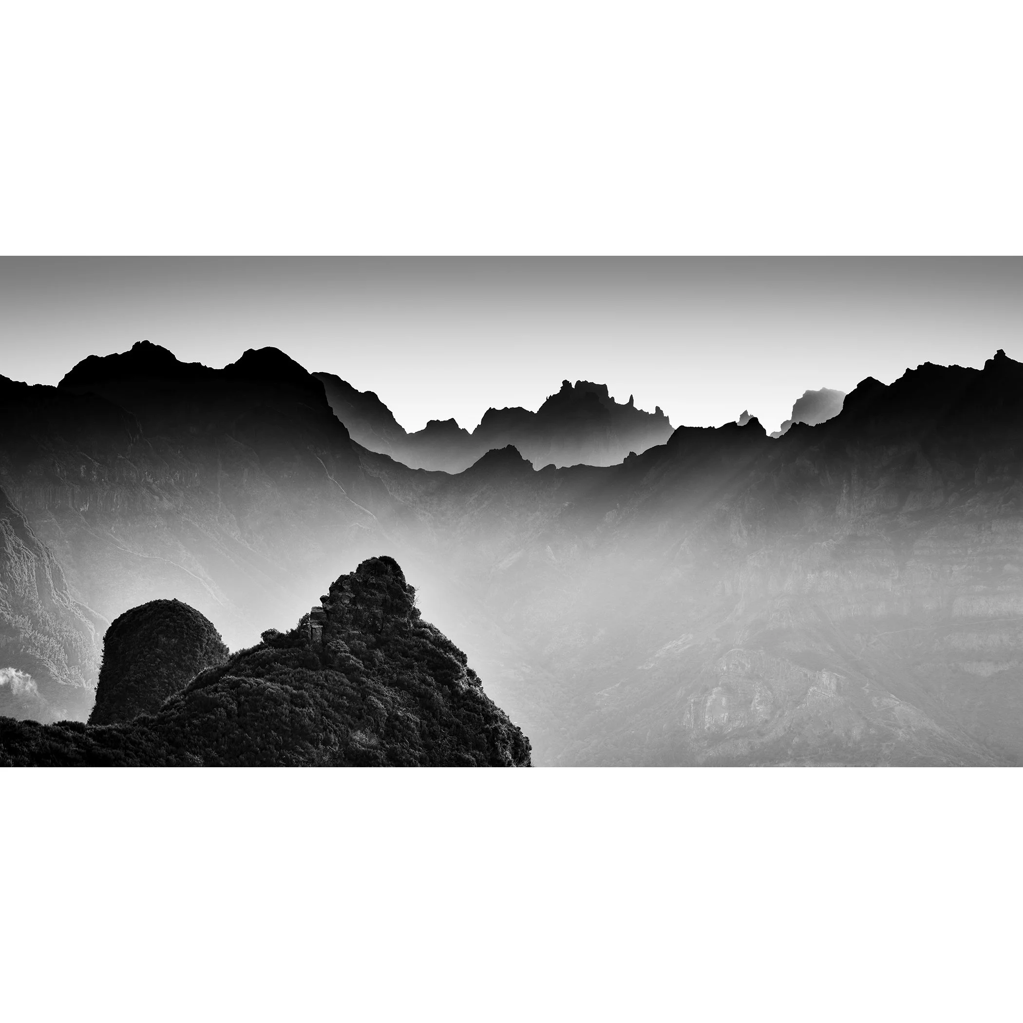 Panoramic black-and-white photograph of misty mountain ridges in Madeira, Portugal, by Gerald Berghammer.