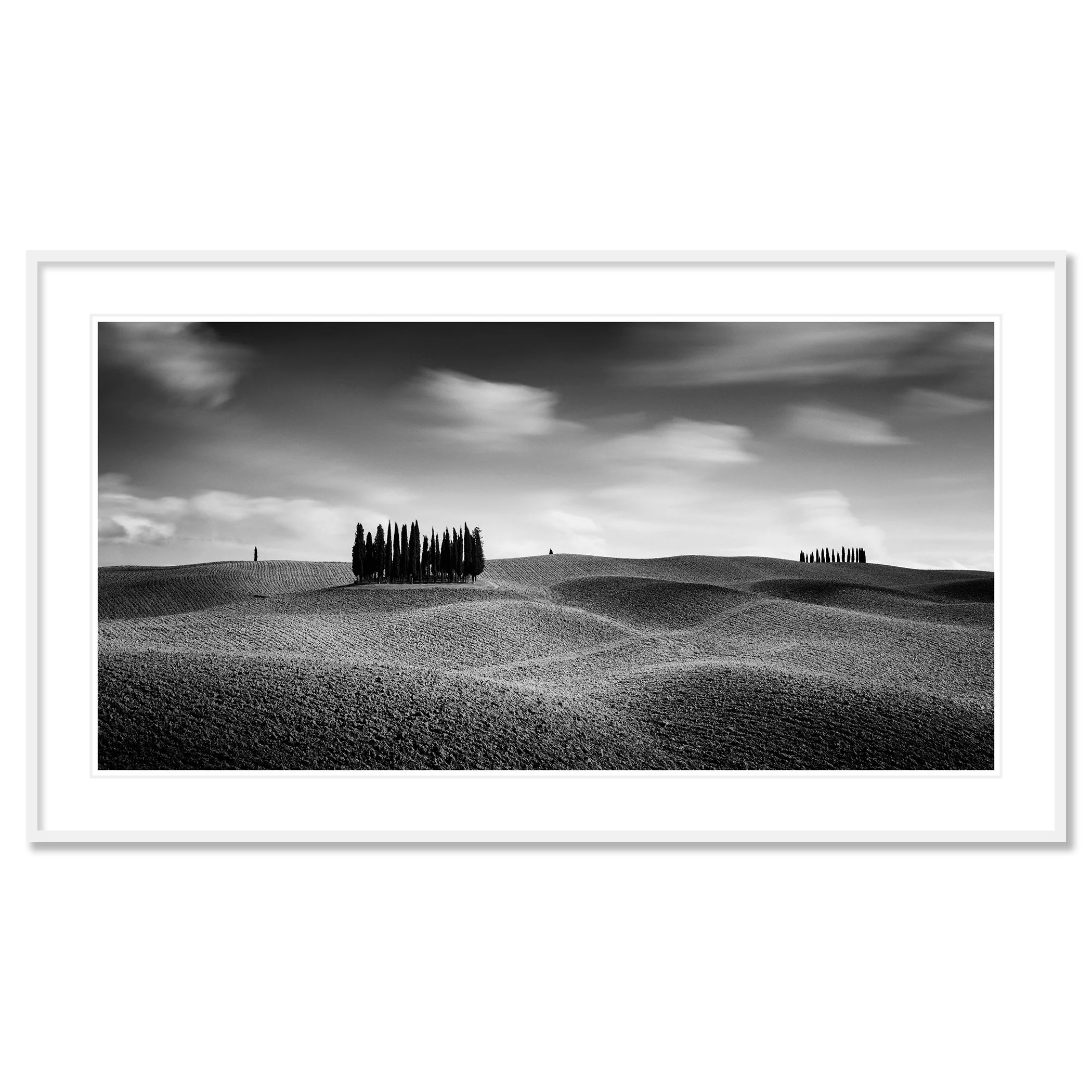 © 2020 Gerald Berghammer - Black and white Tuscan landscape photography. Rolling hills with two clusters of tall, thin trees in the distance, under a cloudy sky. Classic framed white