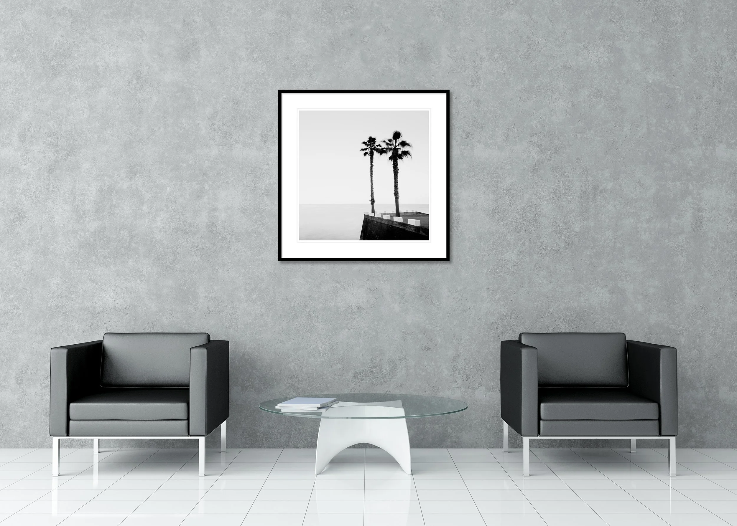 Black and white coastal photo of two tall palm trees by still water and clear sky, archival pigment print in a classic frame with a mount