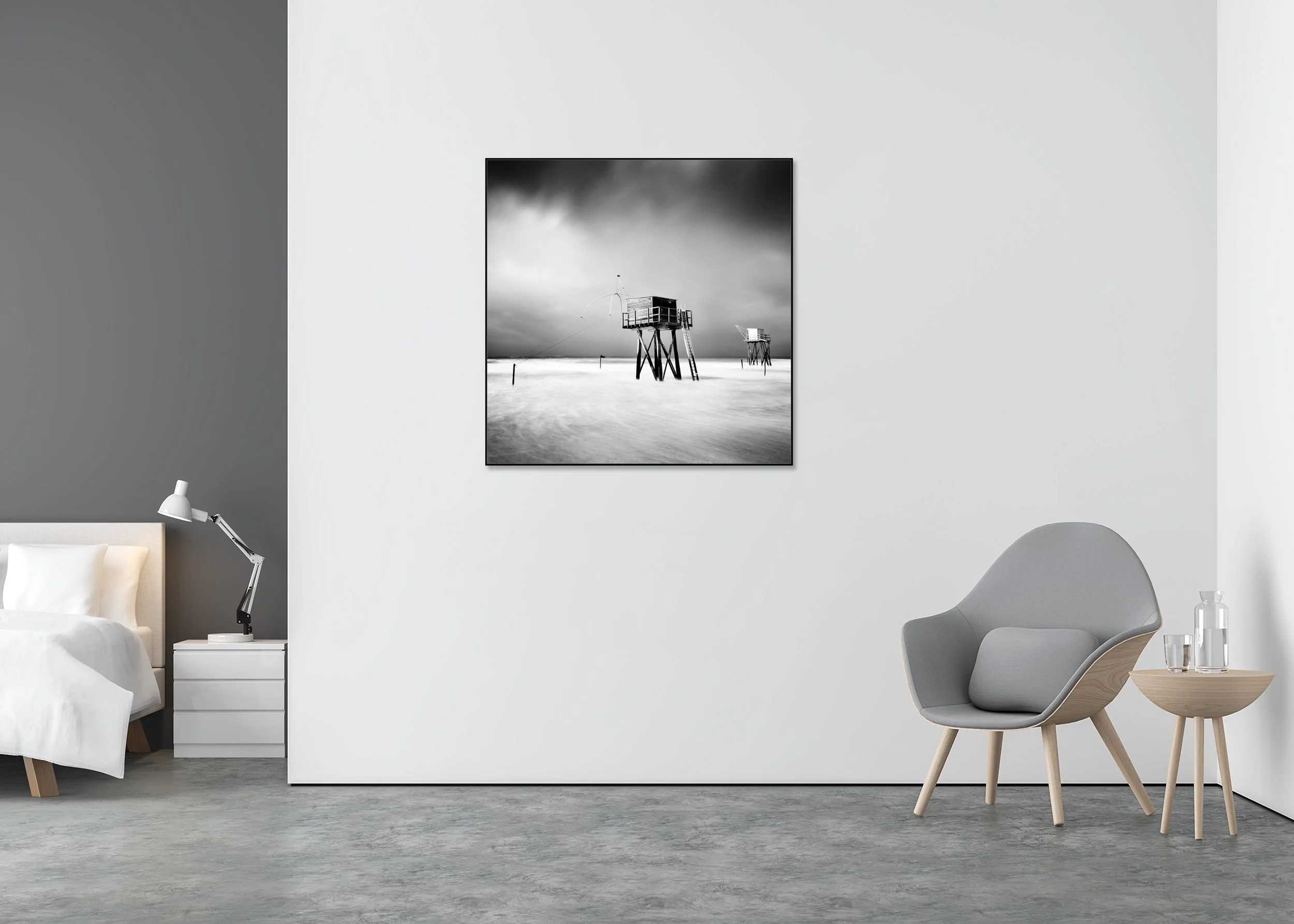Black-and-white long-exposure photo of fishing huts on stilts at sea beneath a dramatic sky, minimalist coastal print mounted to Dibond in an aluminium ArtBox.