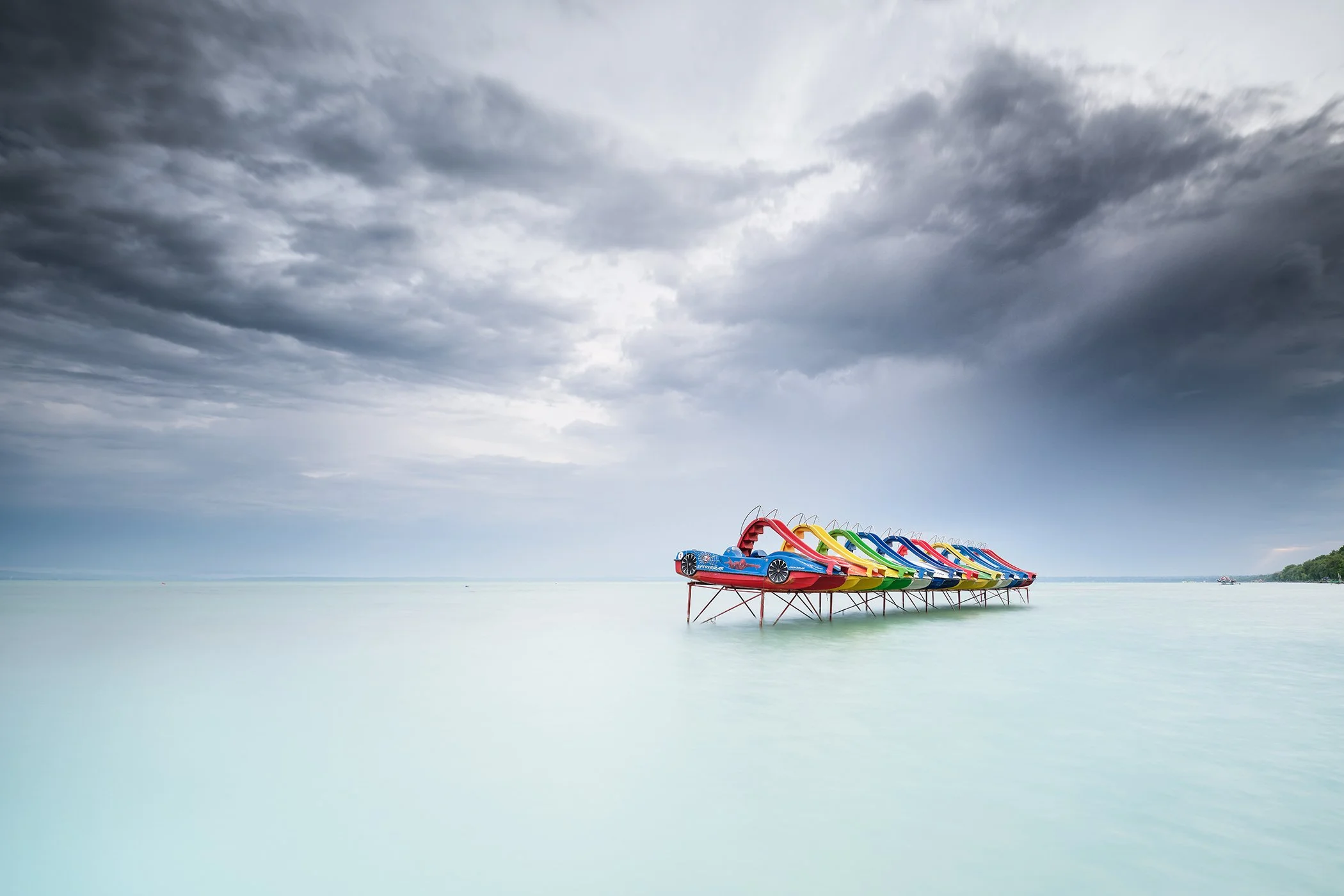 Pedal Boat Colour Study 1, colour fine art photograph of pedal boats beneath dramatic storm clouds on Lake Balaton, Hungary.