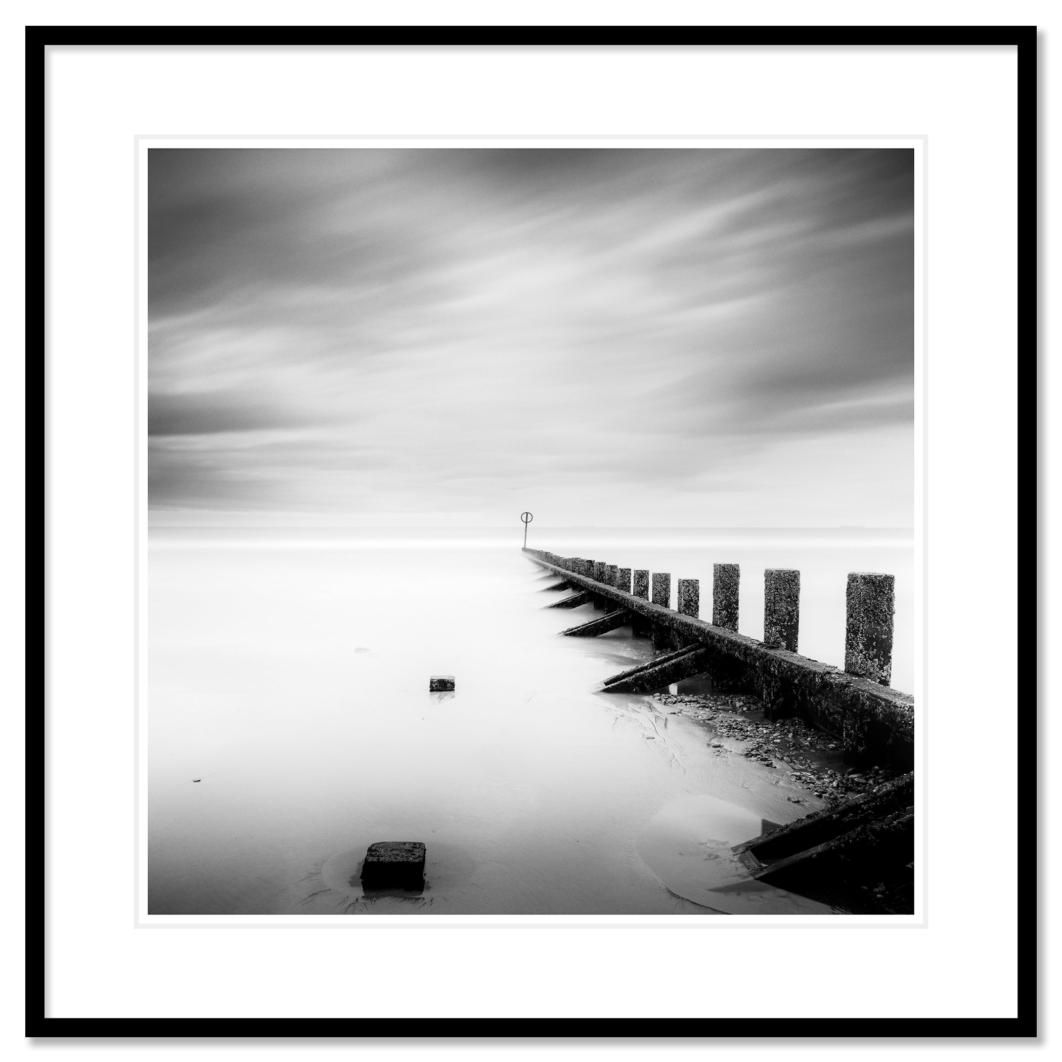 © 2012 Gerald Berghammer - Black and white landscape photography. A wooden wave breaker extending into a calm body of water, with a circular marker at the end. Classic framed black