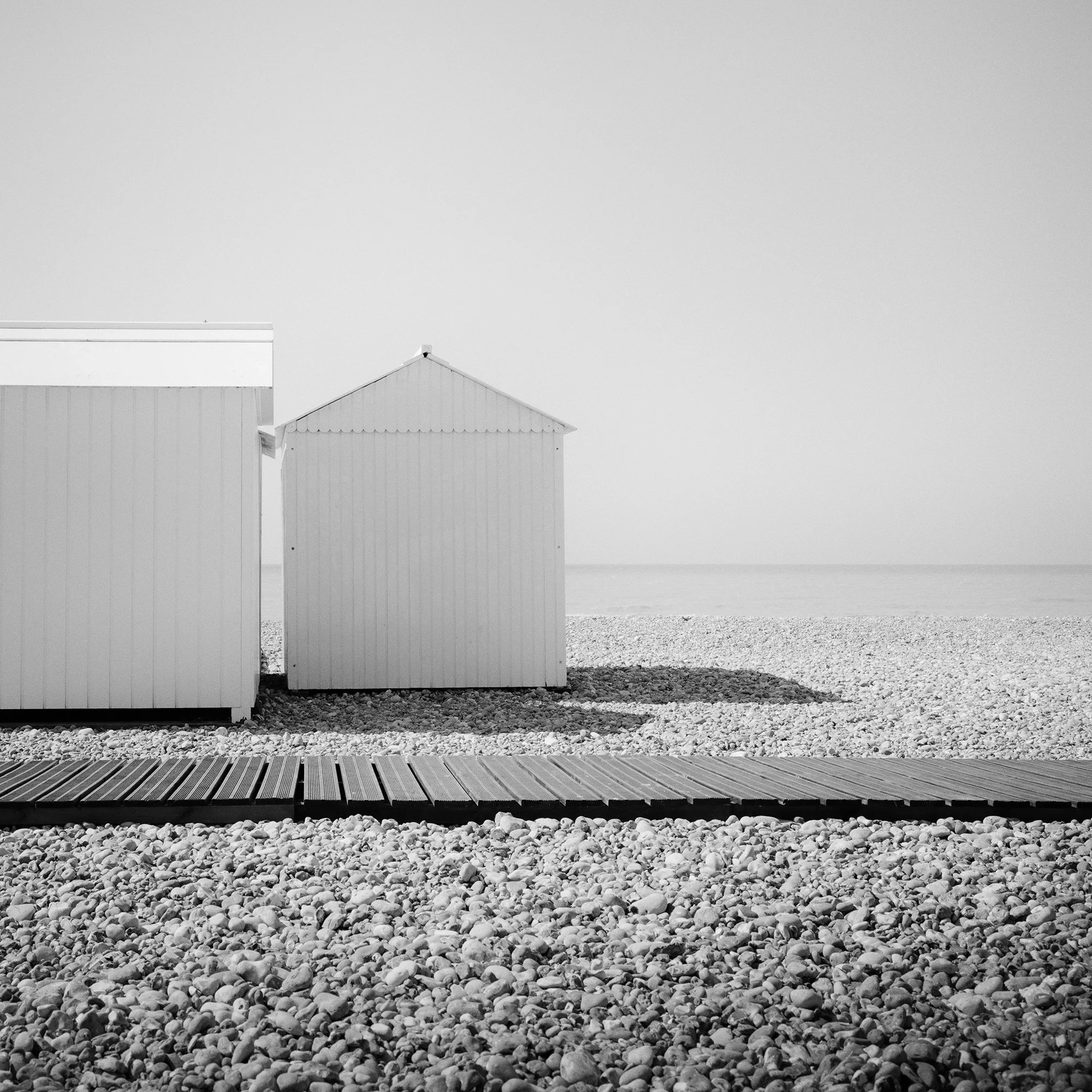 Cropped detail of Esplanade Study 2 by Gerald Berghammer showing the beach huts, wooden walkway and French coastline.