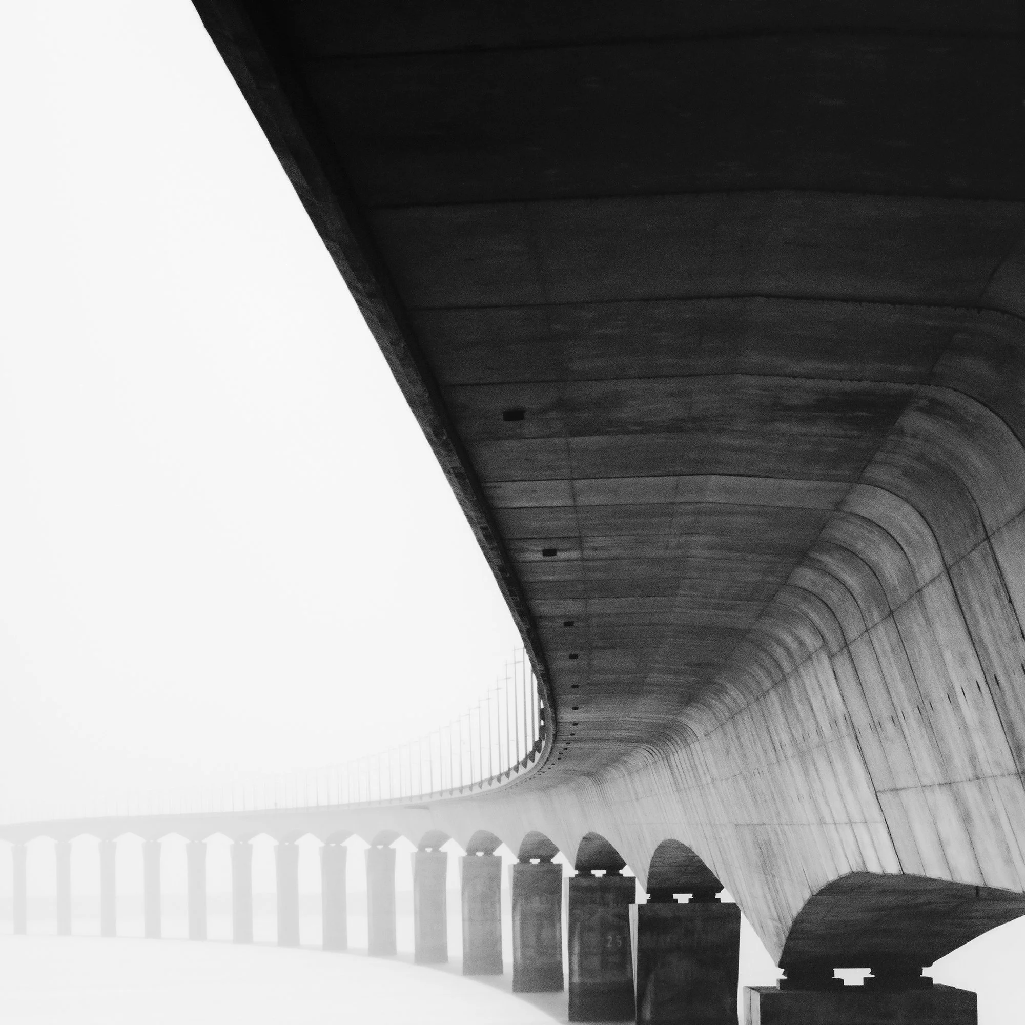Île de Ré Bridge Study 1 – detail of the sweeping concrete underside of the bridge disappearing into mist by Gerald Berghammer.