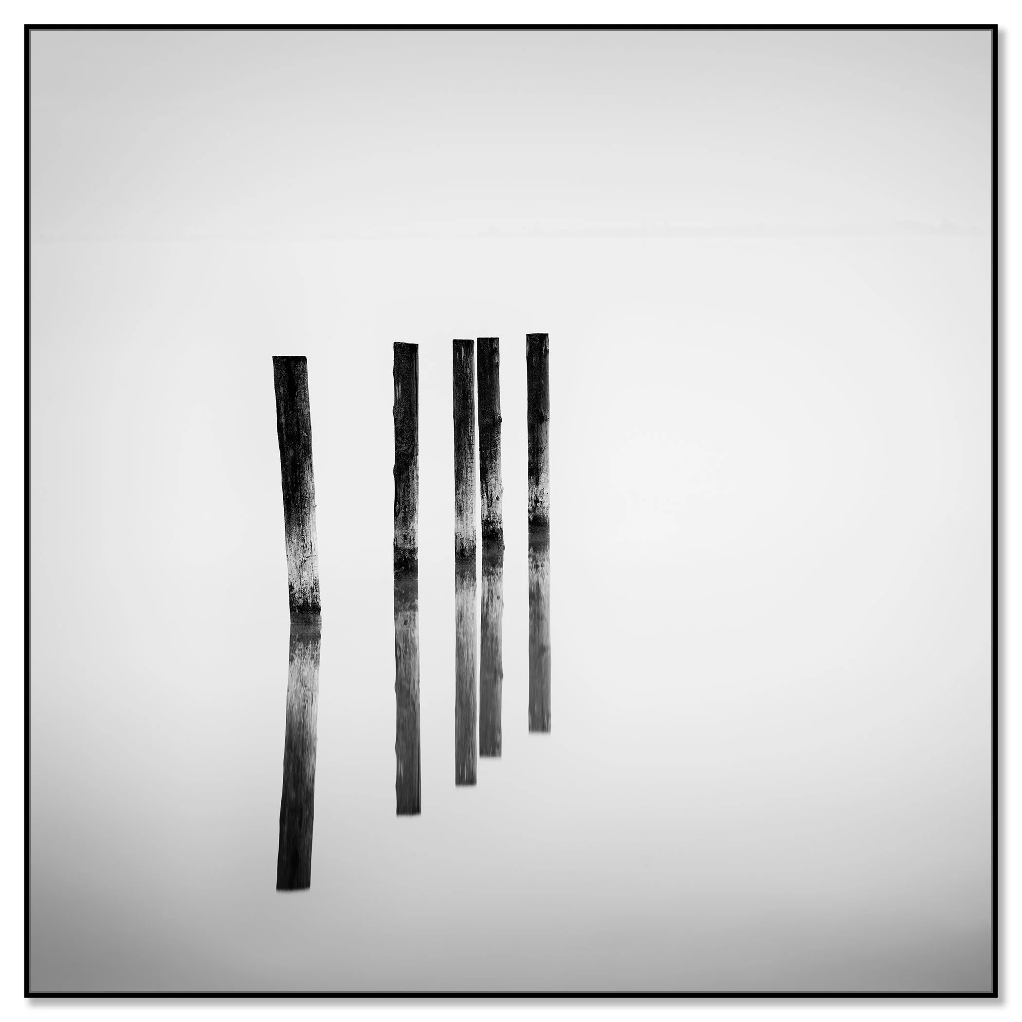 Black and white minimalist image of five vertical wooden posts reflected on a glossy surface – framed ArtBox black