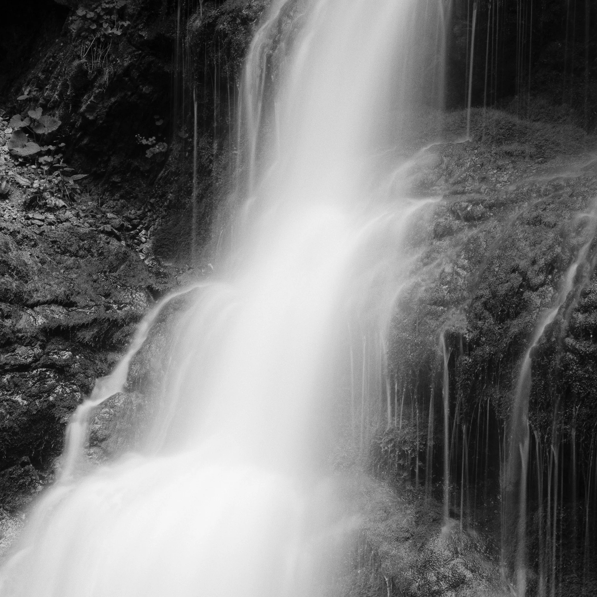 © 2020 Gerald Berghammer - Black and white long exposure abstract photography.  Waterfall descending into a calm pool surrounded by rocky terrain. Print detail 3