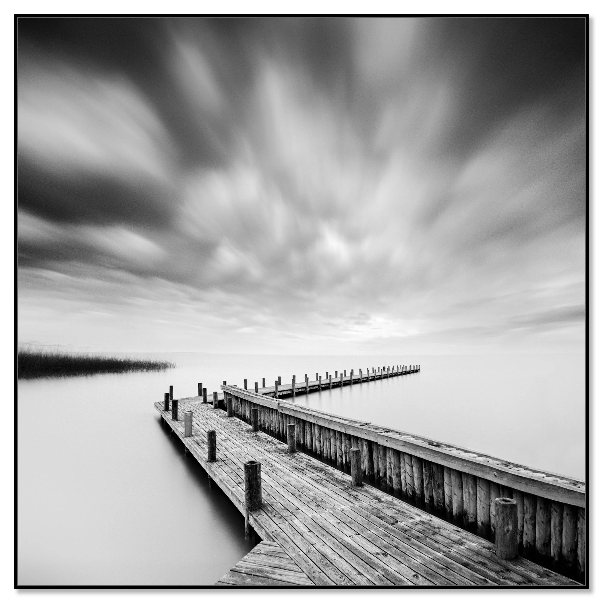 Fine art black and white seascape with an old wooden pier, calm water and dramatic long exposure sky – framed ArtBox black