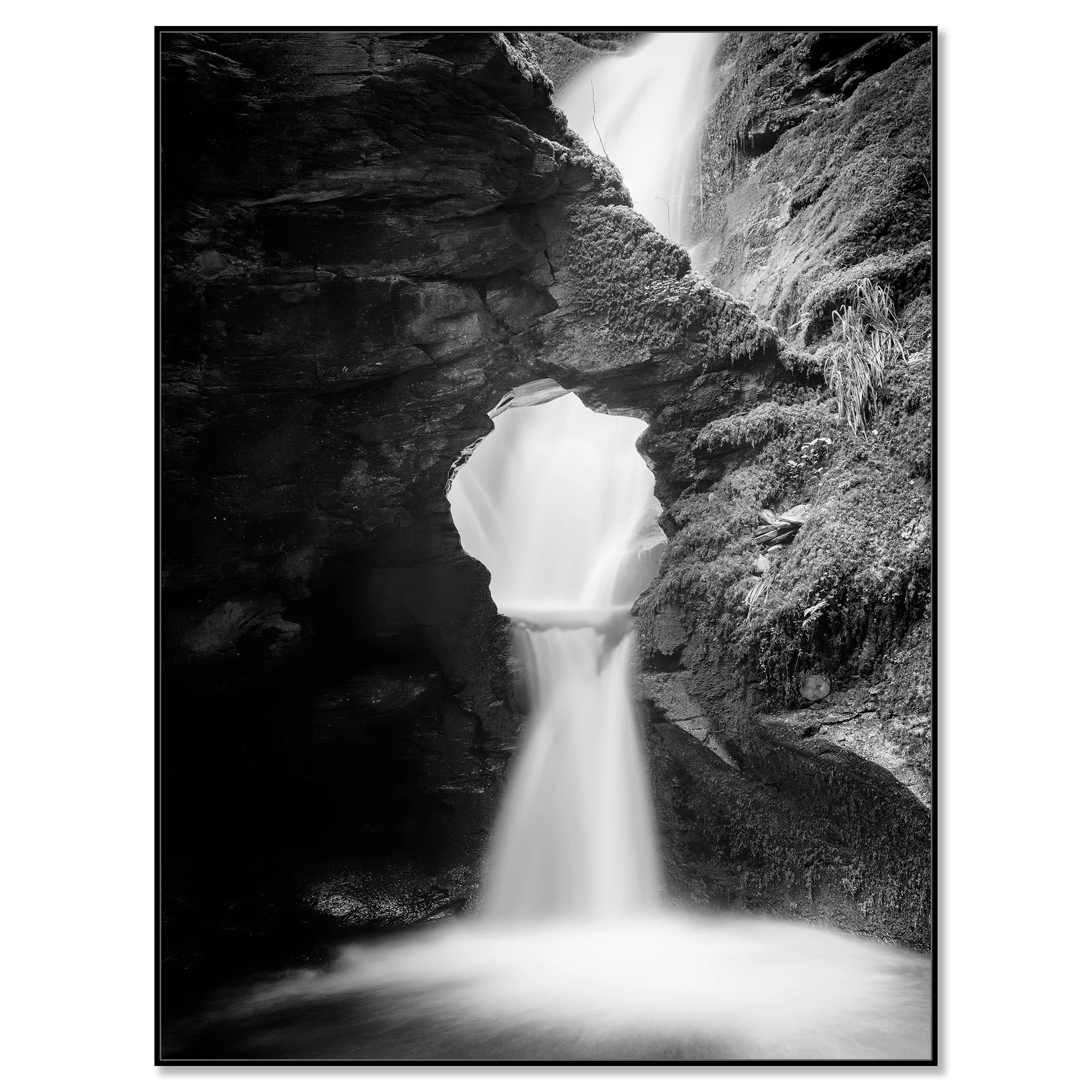 Fine art black and white waterfall print with silky water, rugged rock formations and moss-covered cliffs – framed ArtBox black
