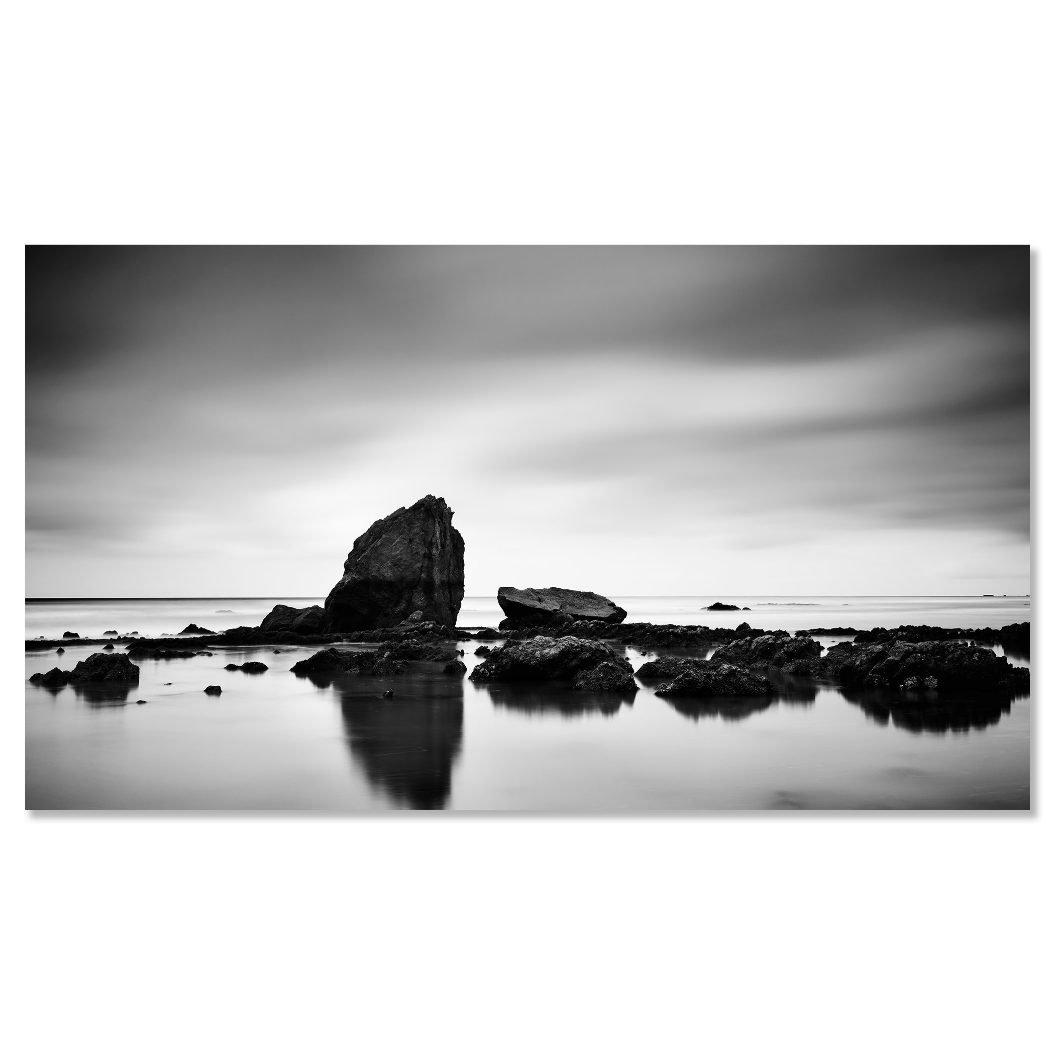 © 2023 Gerald Berghammer - Black and white minimalist beach seascape. A rocky shoreline with a large prominent rock formation in the water. Chromaluxe frameless