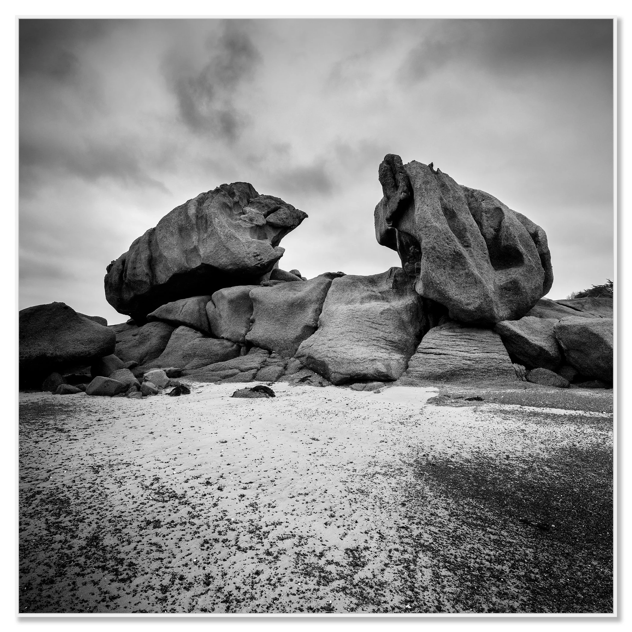 Monochrome coastal landscape with giant granite rocks and sandy beach along a rugged coast – framed ArtBox white