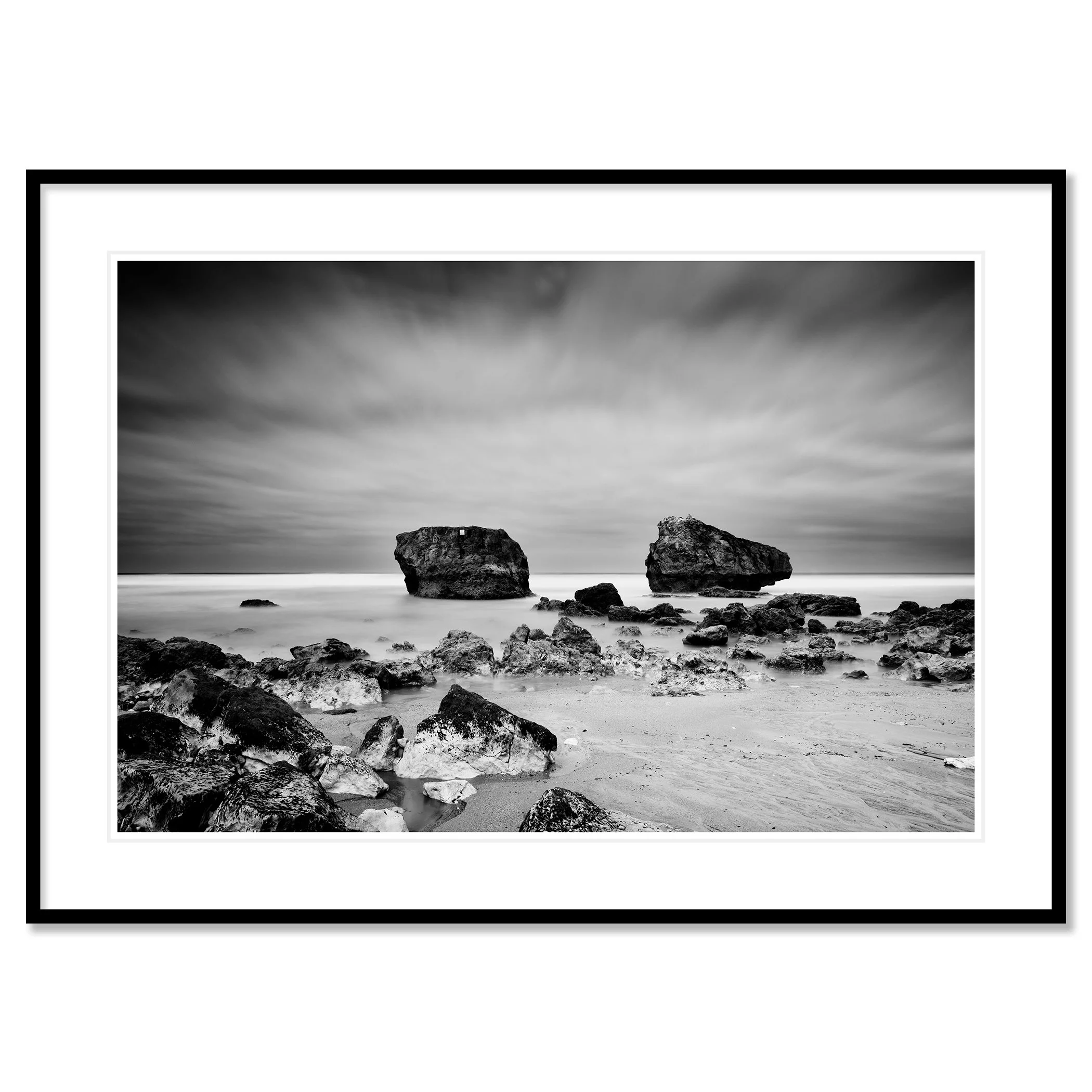 Gerald Berghammer - Black and white landscape photo. Rocky beach with two large rocks protruding from the water, cloudy sky, and smooth ocean surface. Classic framed black