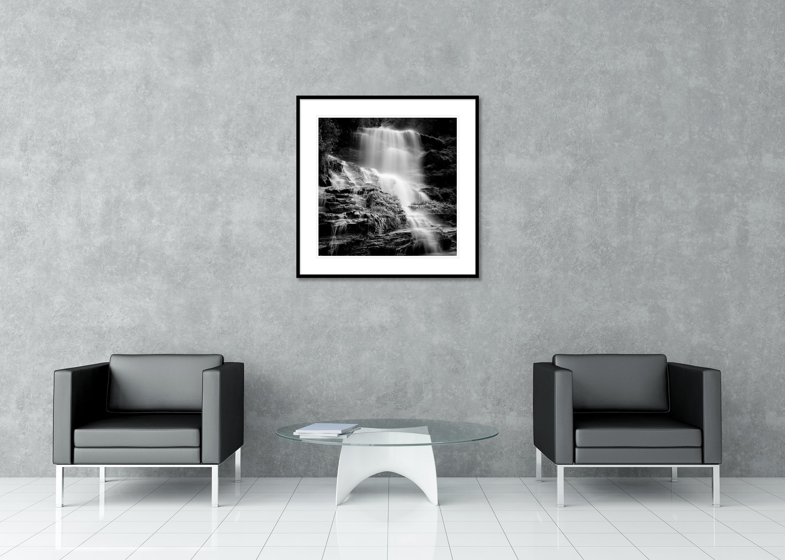 Black-and-white cascading waterfall with long-exposure misty water over dark rocks, archival pigment photo print in a classic frame with a mount.
