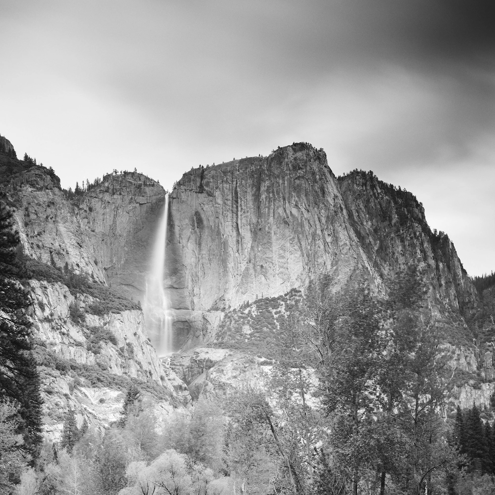 © 2015 Gerald Berghammer - Black and white american landscaspe photography. Mountain landscape with a waterfall, trees, and a calm river in the foreground. Print detail 1