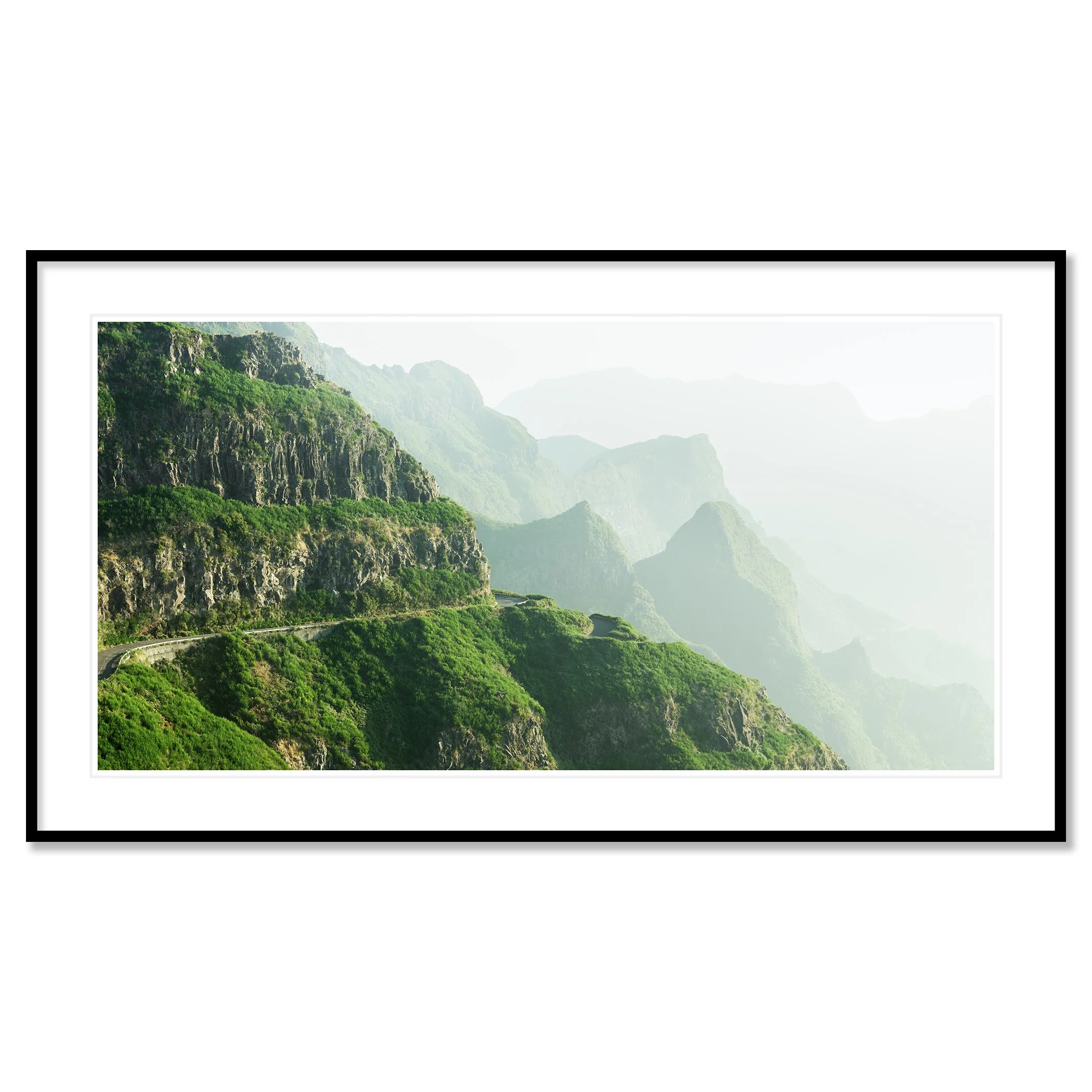 © 2021 Gerald Berghammer - Color Fine Art Landscape Photography. A winding mountain road through lush green cliffs and misty mountains in the background. Classic framed black
