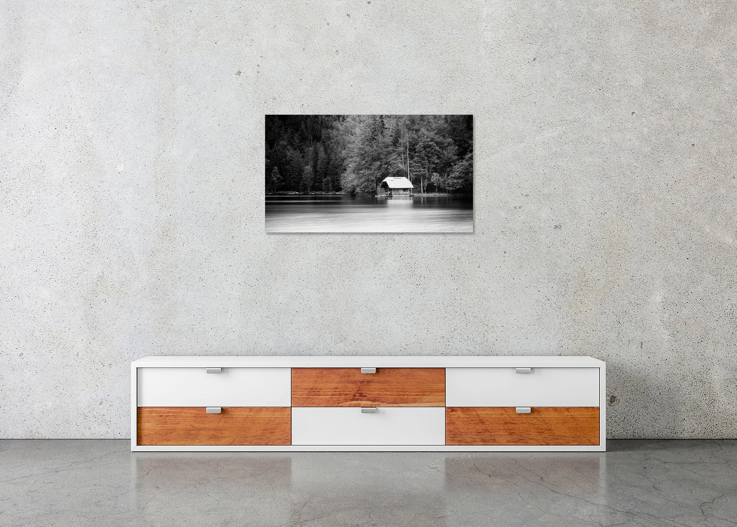 Black-and-white long-exposure of a tranquil lake with a small boathouse by the forest and glassy, calm water; photo print mounted to Dibond, frameless.