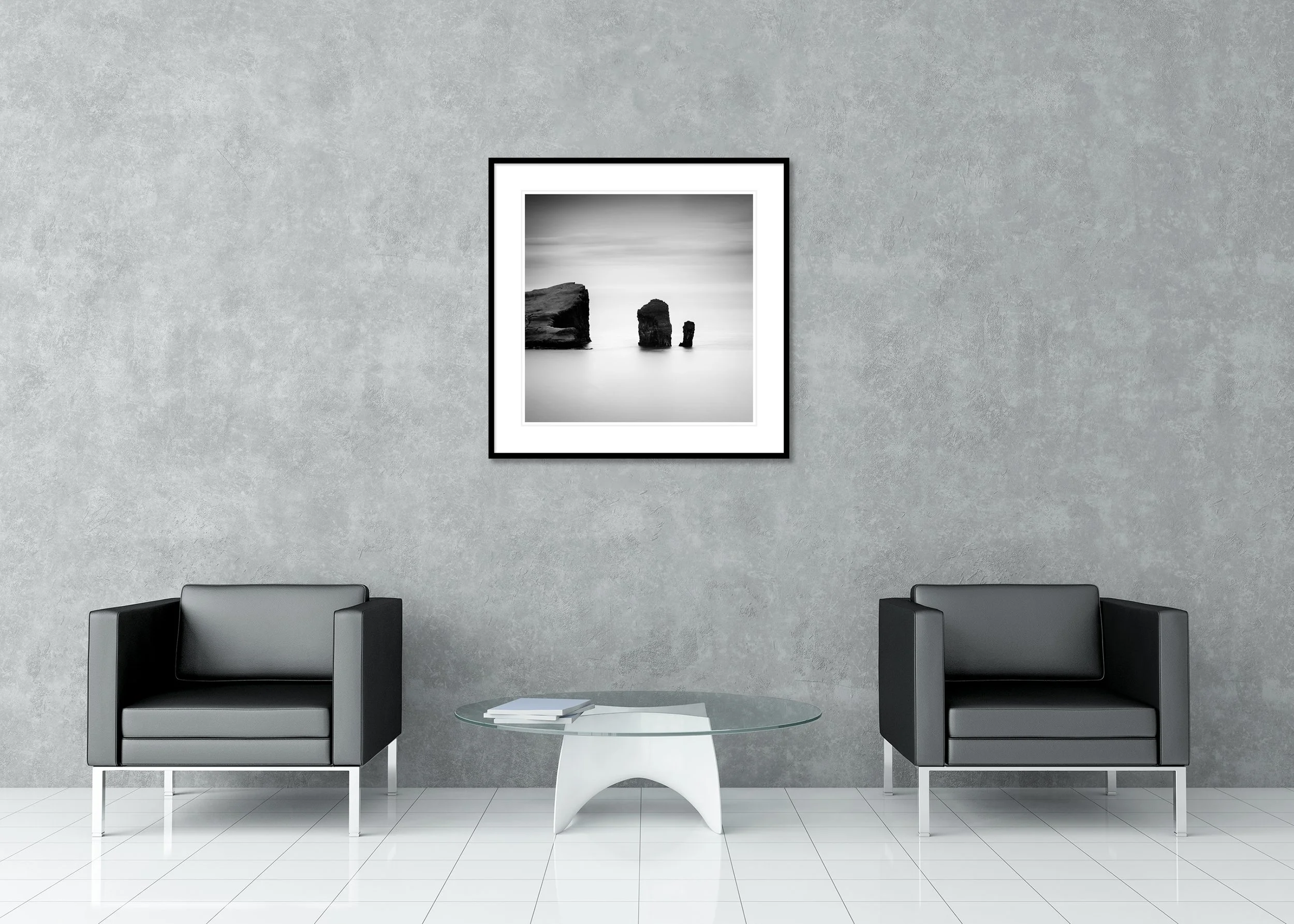 Minimalist black and white photo print of rock formations in calm sea water, Faroe Islands, archival pigment print in a classic frame with mount.