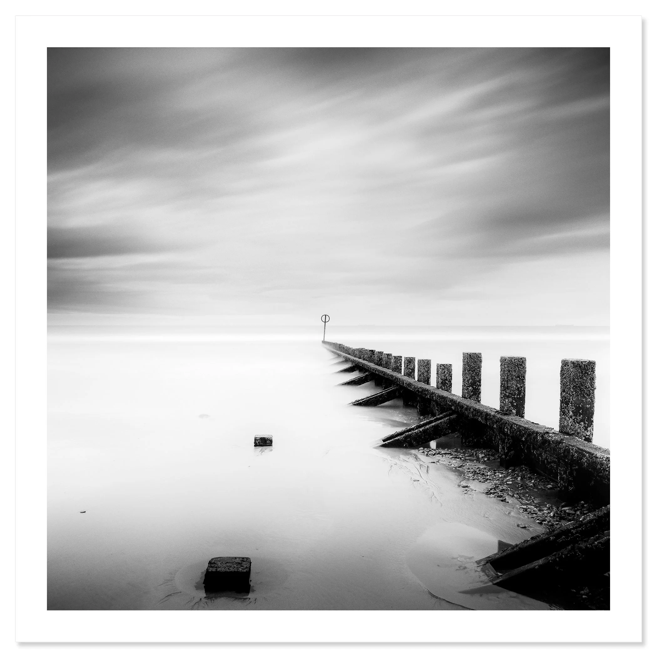 © 2012 Gerald Berghammer - Black and white landscape photography. A wooden wave breaker extending into a calm body of water, with a circular marker at the end. Fine art print only