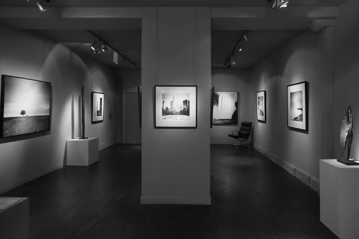 Black-and-white installation view of Galerie Arnoux in Paris featuring minimalist landscape and cityscape photographs by Gerald Berghammer, 2017.