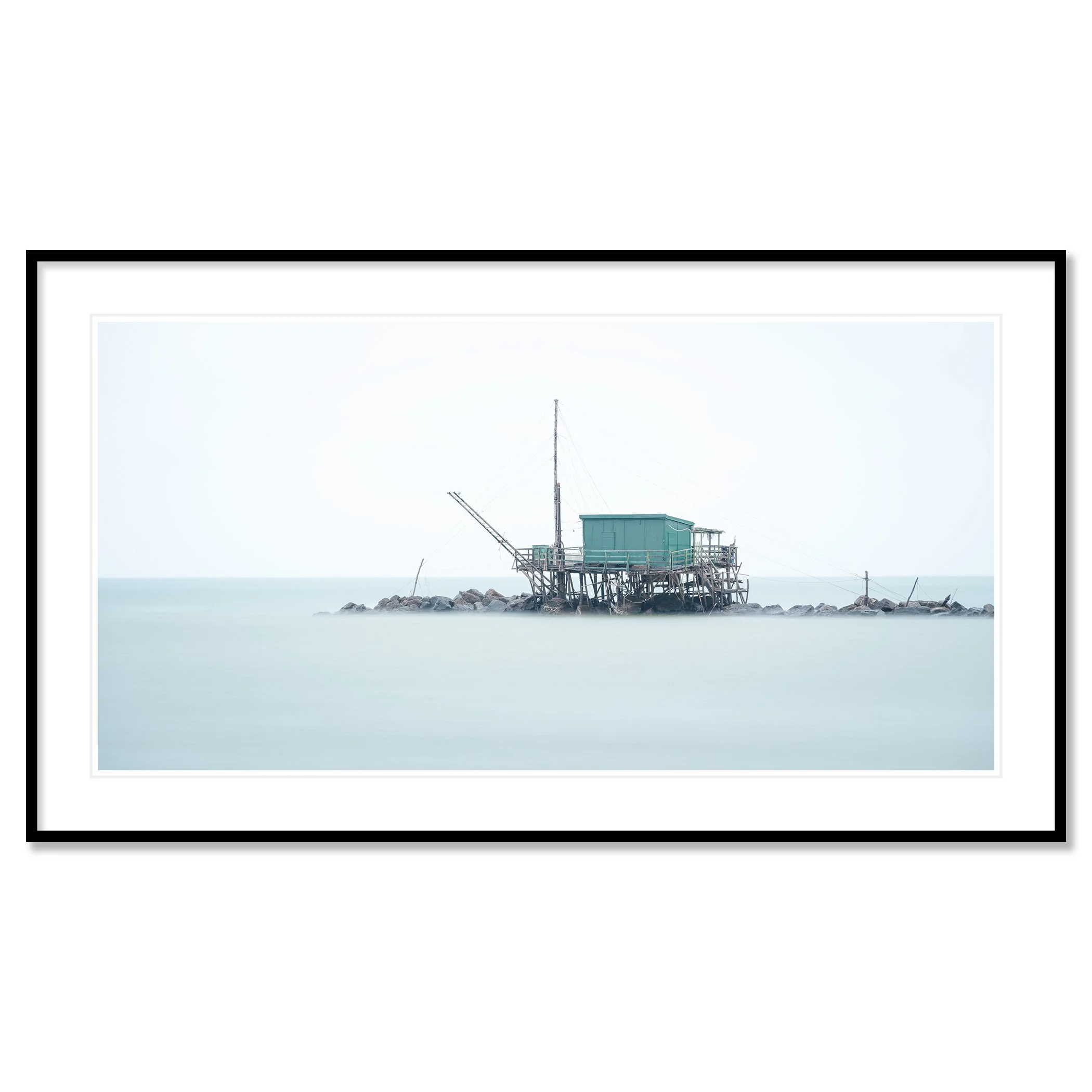 © 2024 Gerald Berghammer - Color minimalist photography. A small house built on stilts over water on rocks, with a fishing pole, in a minimalist, misty seascape. Classic framed black