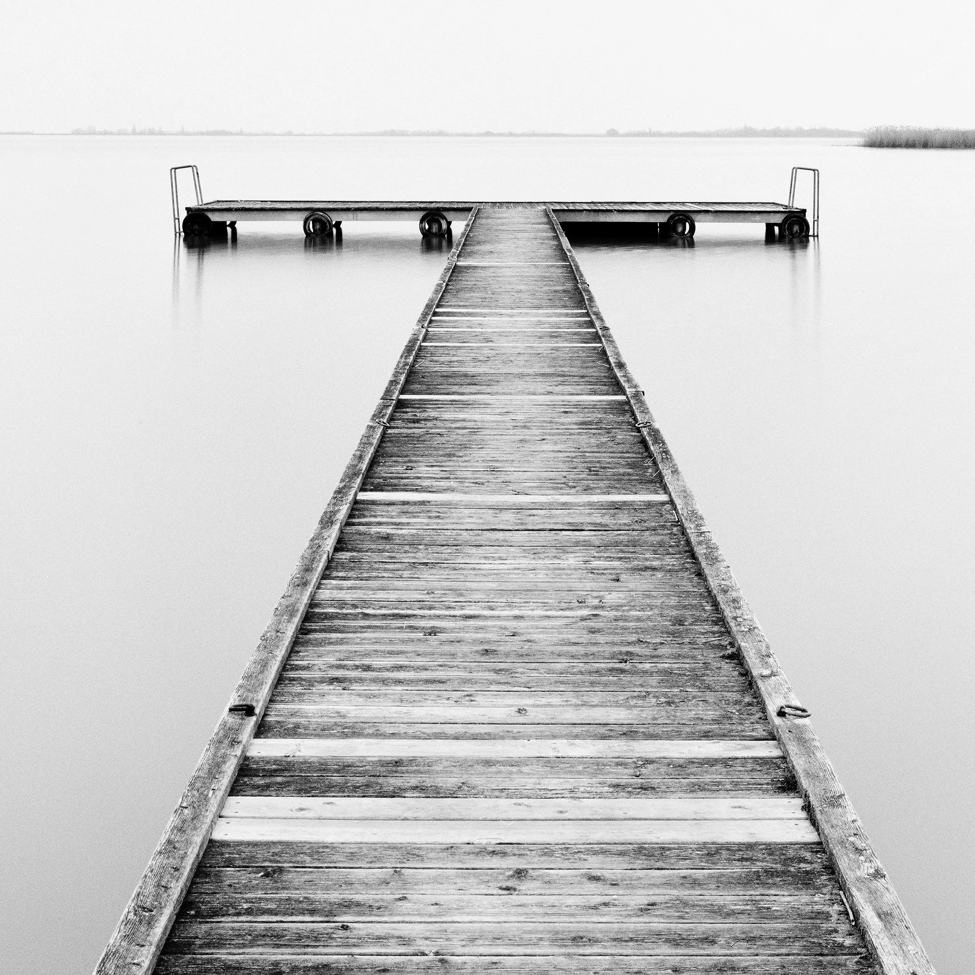 Close-up of Pier Study 1 showing the weathered wooden pier and calm waters of Lake Neusiedl, Austria, by Gerald Berghammer.