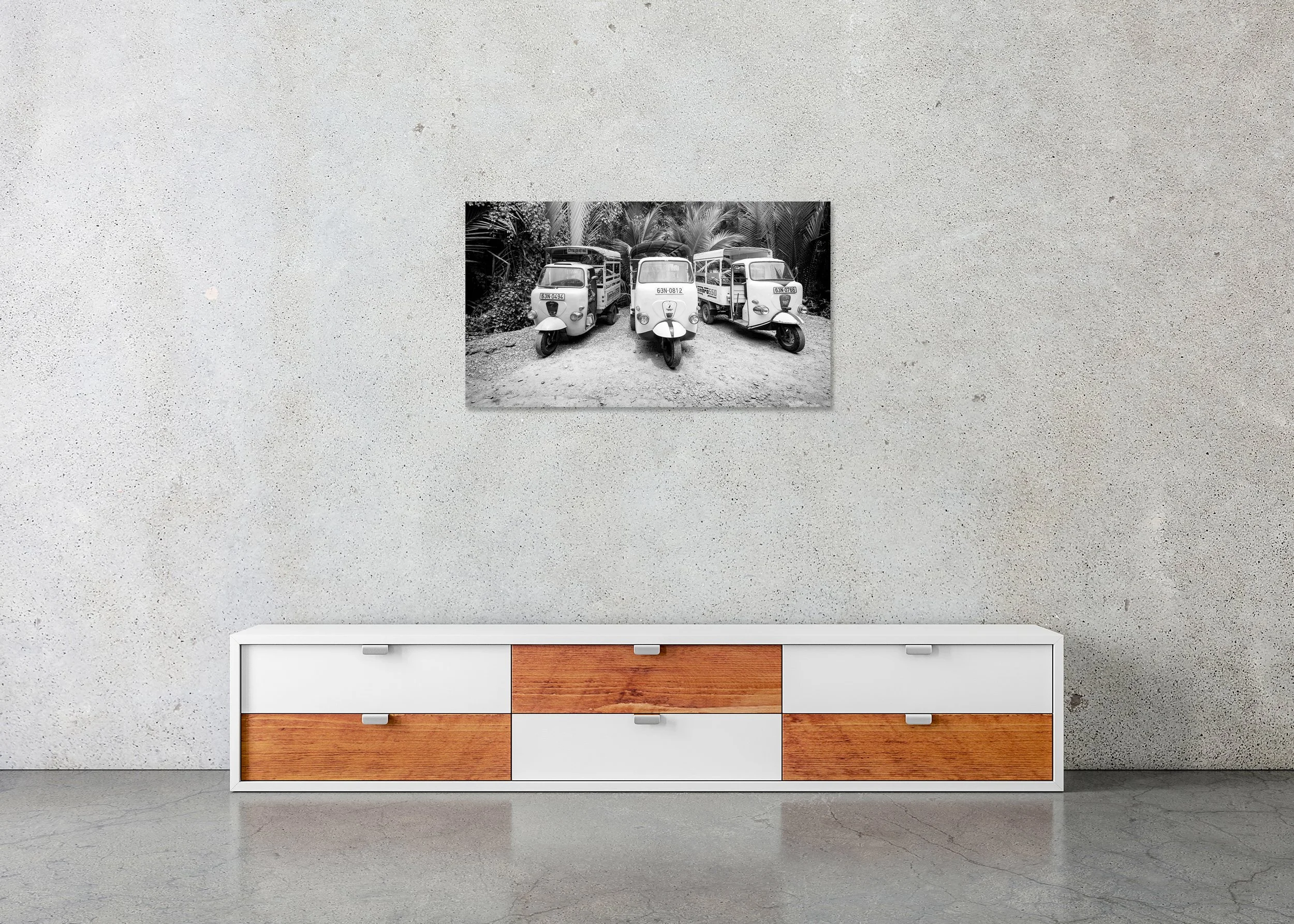 Monochrome image of three tuk-tuks parked side by side on a gravel path amid dense tropical foliage, photo print mounted to Dibond, frameless.