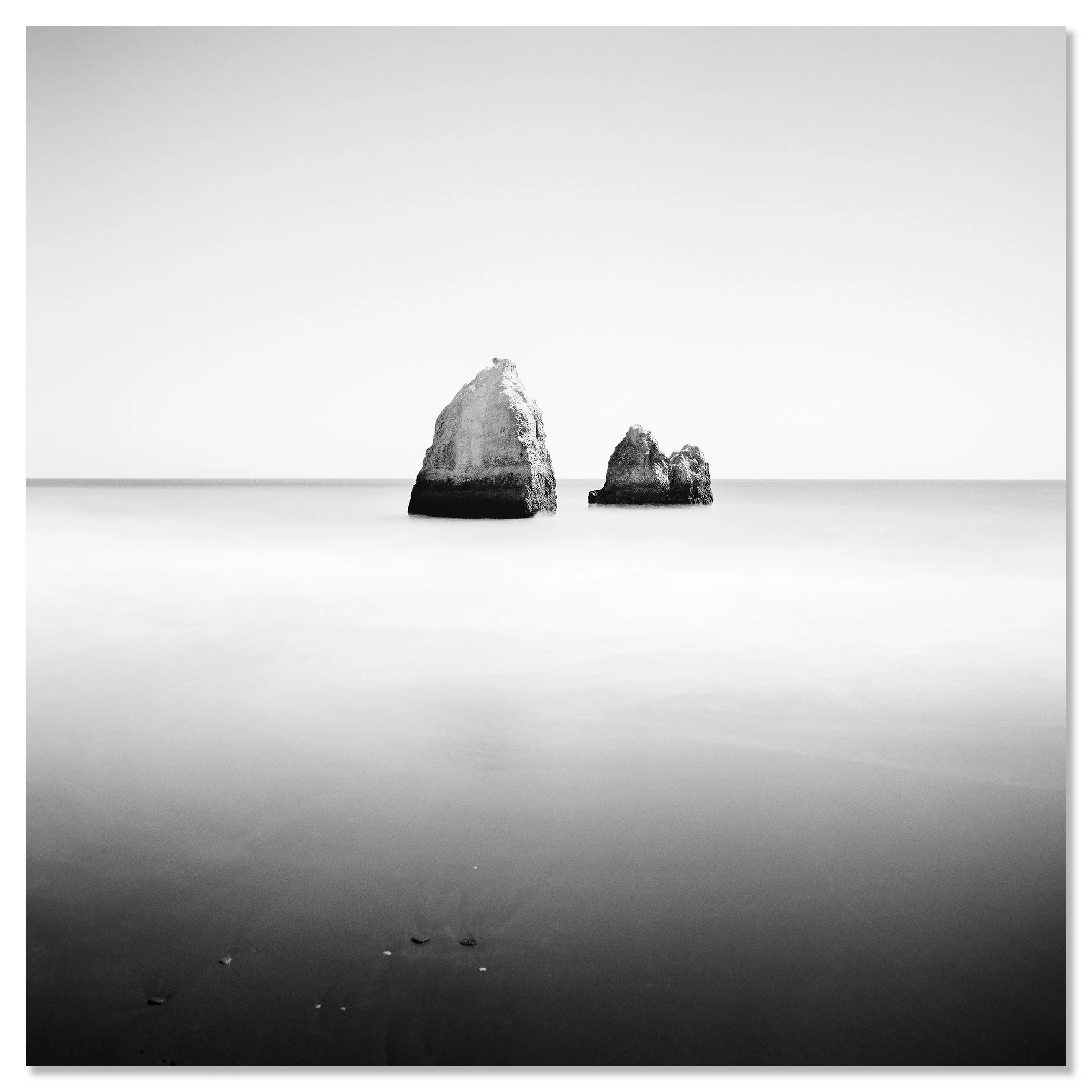 Gerald Berghammer - Long Exposure Seascape Photography. Two large rocks in calm ocean water, black and white photo with minimalistic composition. Chromaluxe frameless
