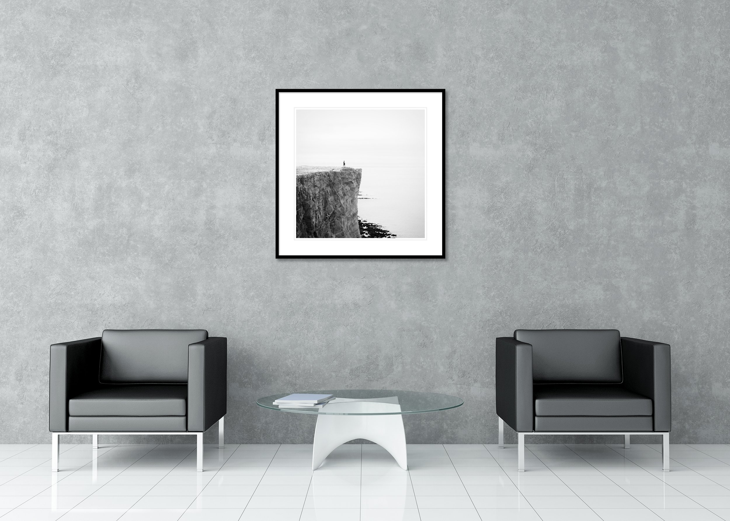 Black-and-white minimalist landscape print of a lone figure on white cliffs above the sea on the England coast, archival pigment print in a classic frame with a mount
