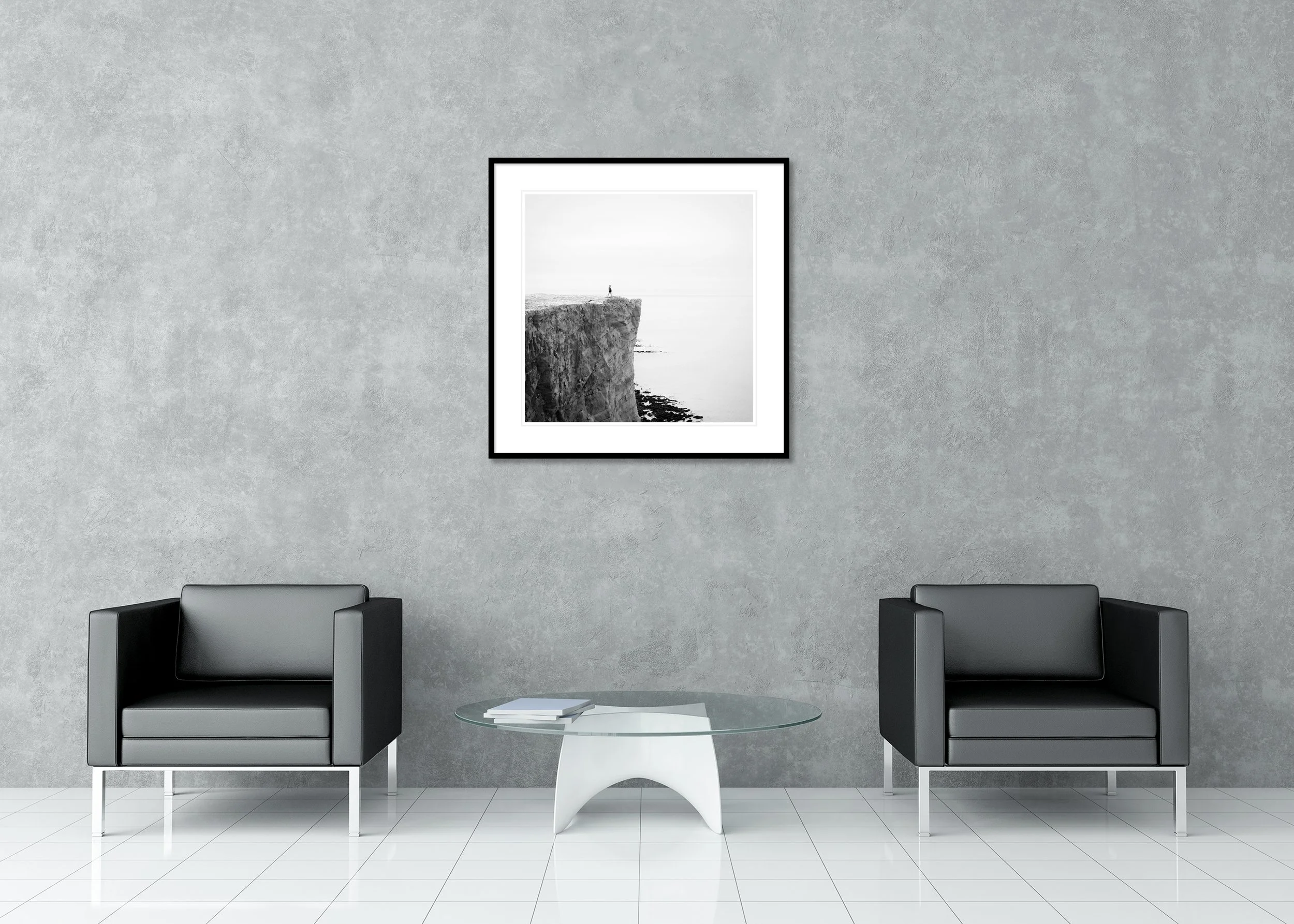 Black-and-white minimalist landscape photograph of a lone figure on white cliffs above the sea on the England coast, archival pigment print in a classic frame with passe-partout