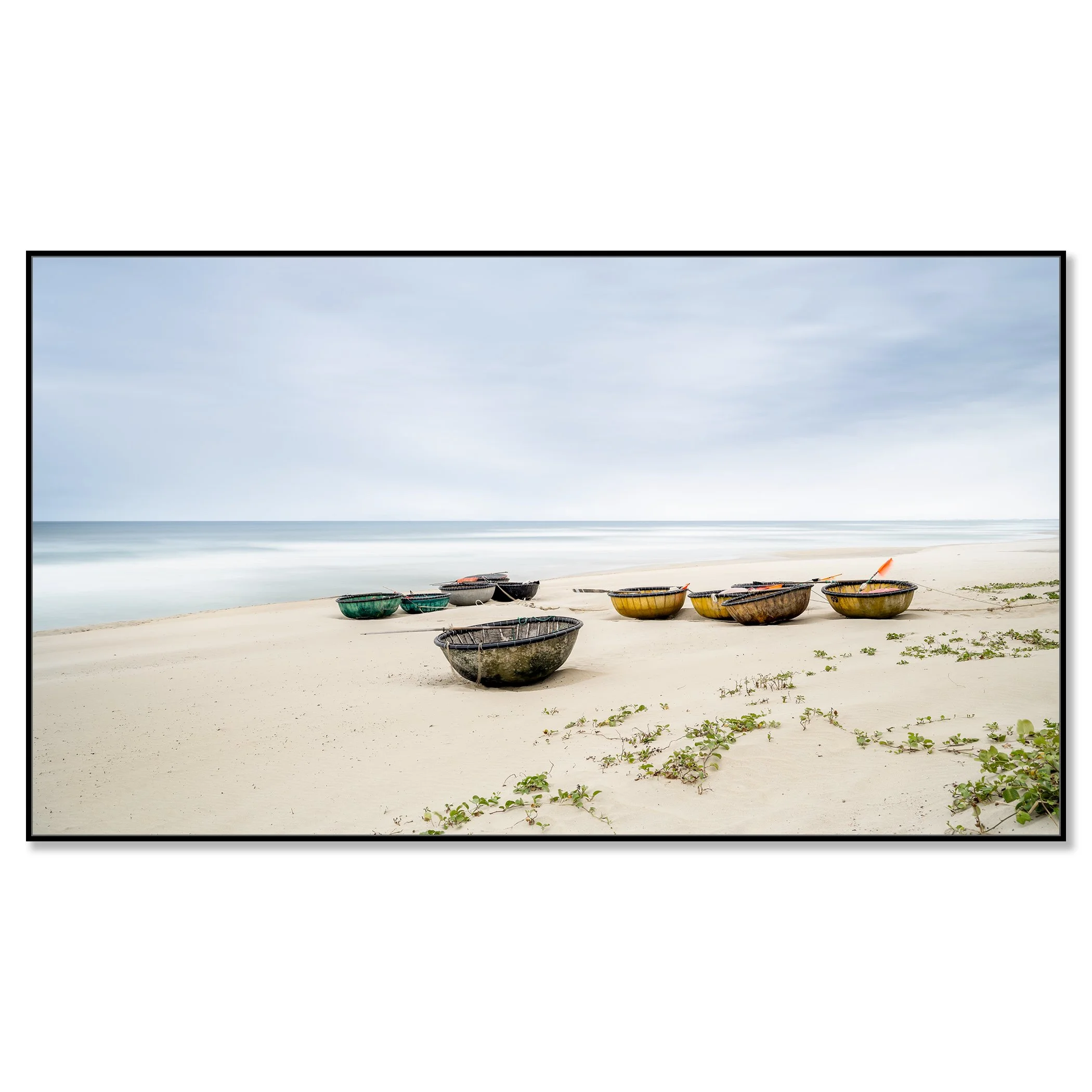 Colorful coconut boats on sandy beach in Vietnam, calm sea, sparse green vegetation under cloudy sky – framed ArtBox black