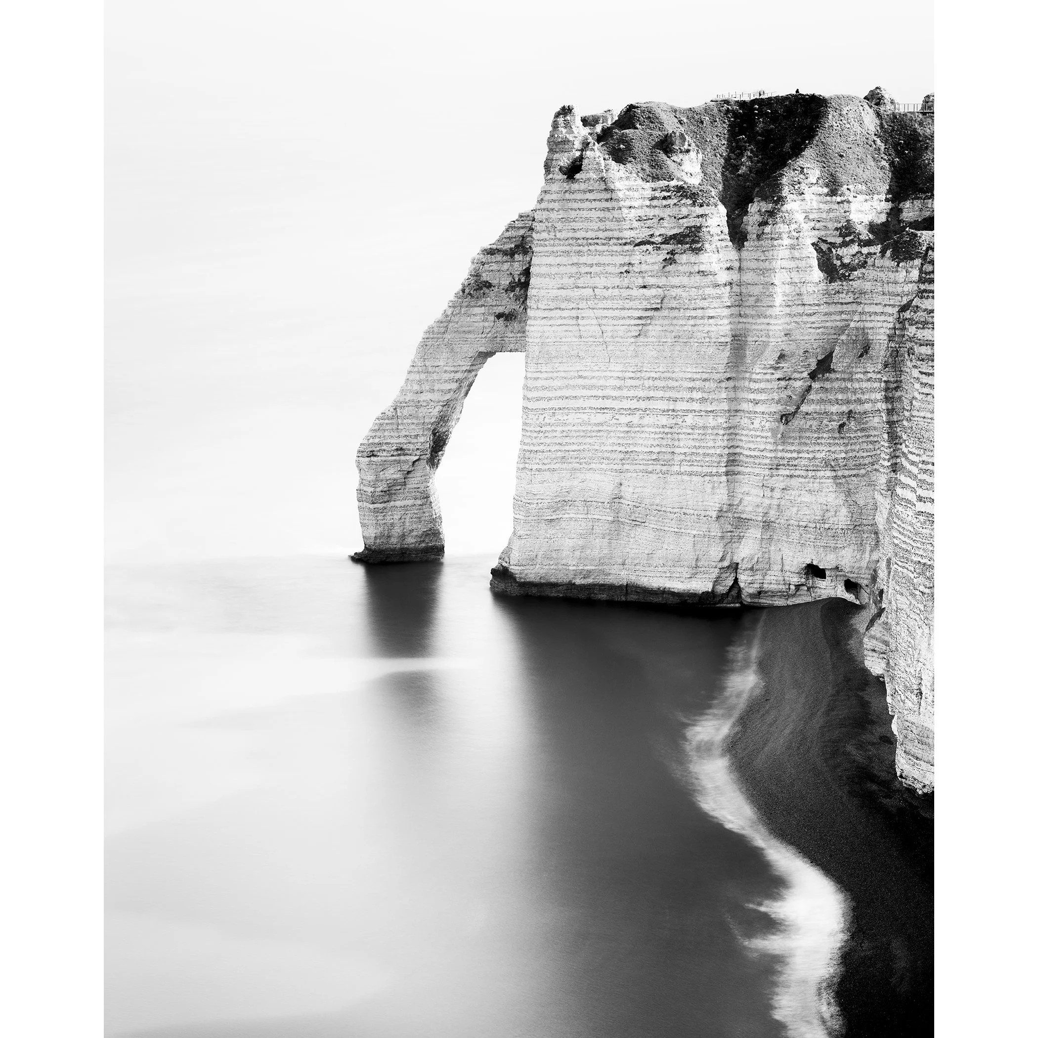 The Sea Arch at Étretat, France, black-and-white long-exposure photograph. Photo by Gerald Berghammer.