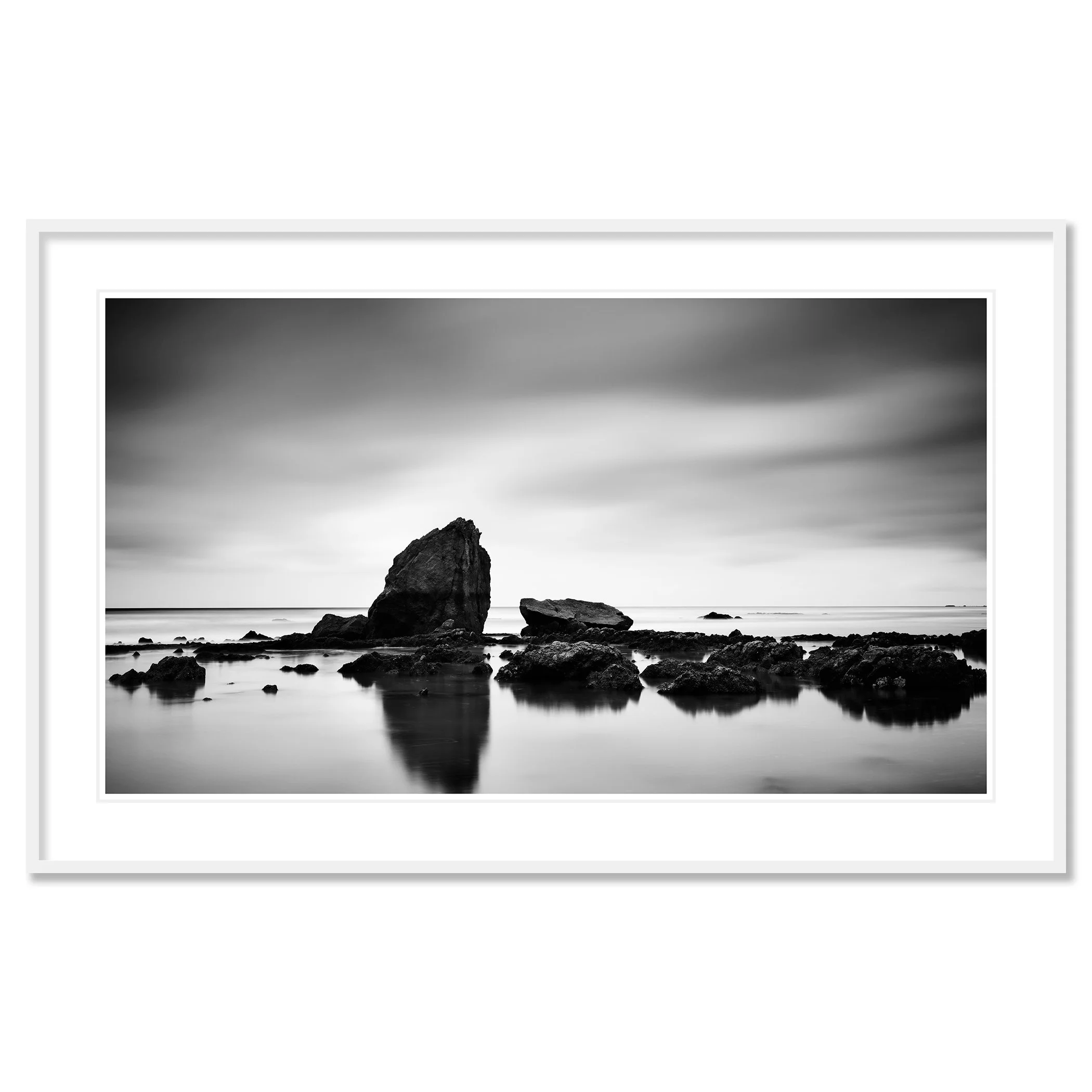 © 2023 Gerald Berghammer - Black and white minimalist beach seascape. A rocky shoreline with a large prominent rock formation in the water. Classic framed white
