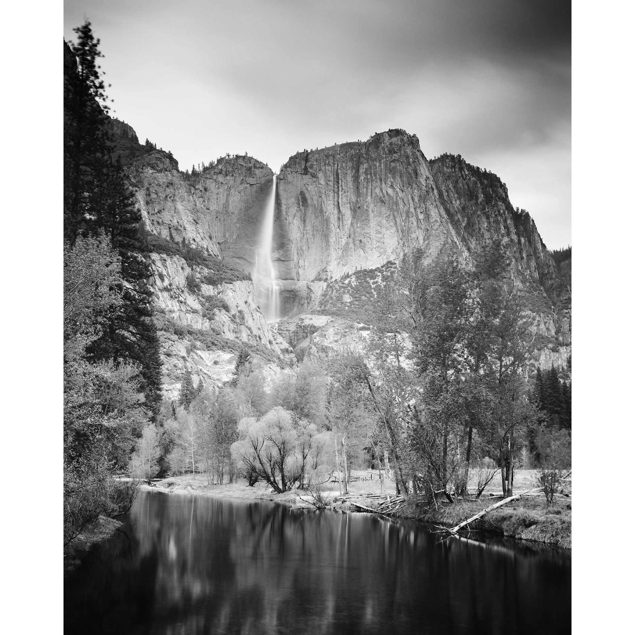 © 2015 Gerald Berghammer - Black and white american landscaspe photography. Mountain landscape with a waterfall, trees, and a calm river in the foreground.