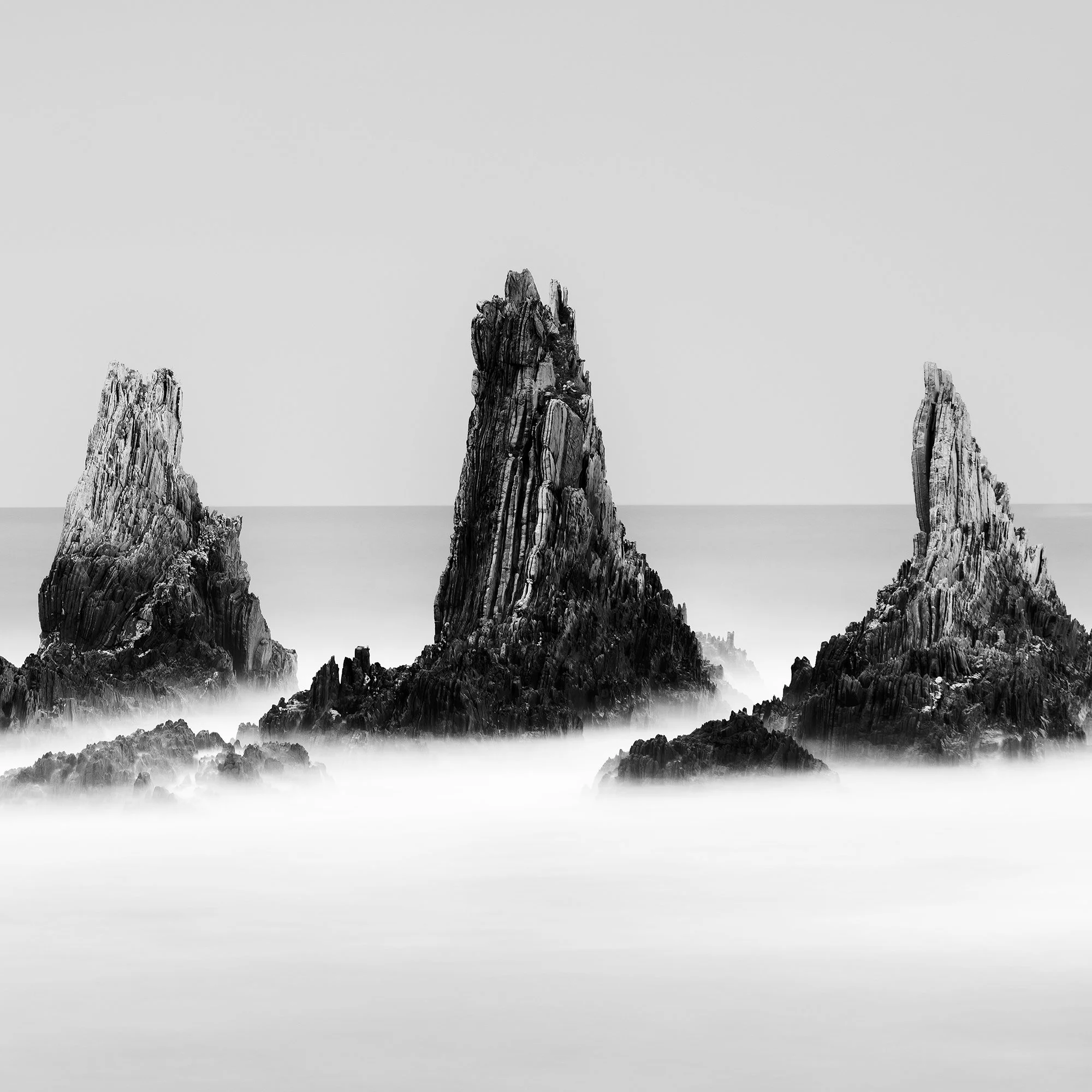 Close-up of three jagged rock formations in Rocky Peaks Panorama, Study 2, a black-and-white seascape from Spain by Gerald Berghammer.