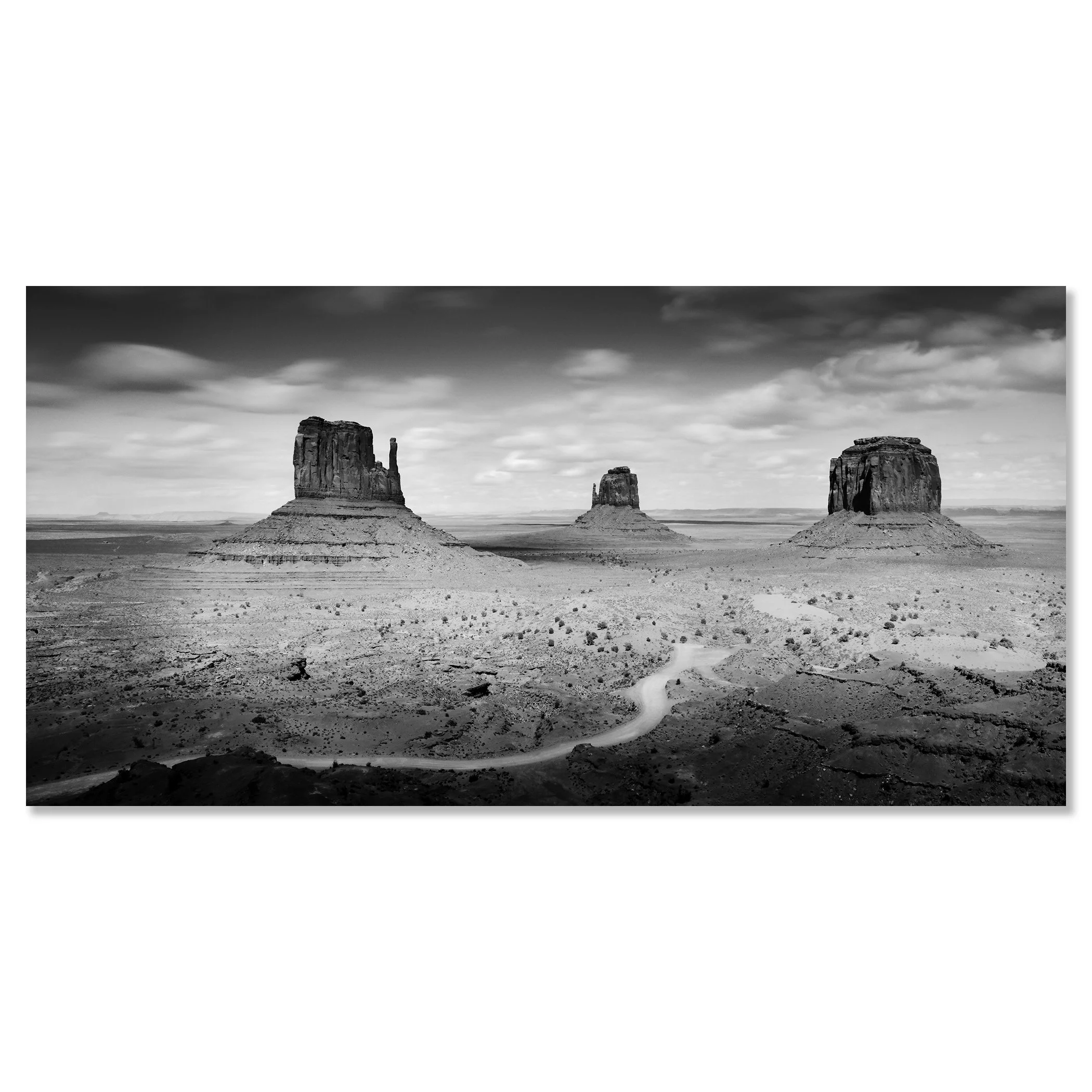 © 2015 Gerald Berghammer - Black and white photo. Large rock formations in a desert landscape, with a winding dirt road in the foreground and a cloudy sky above. Chromaluxe frameless