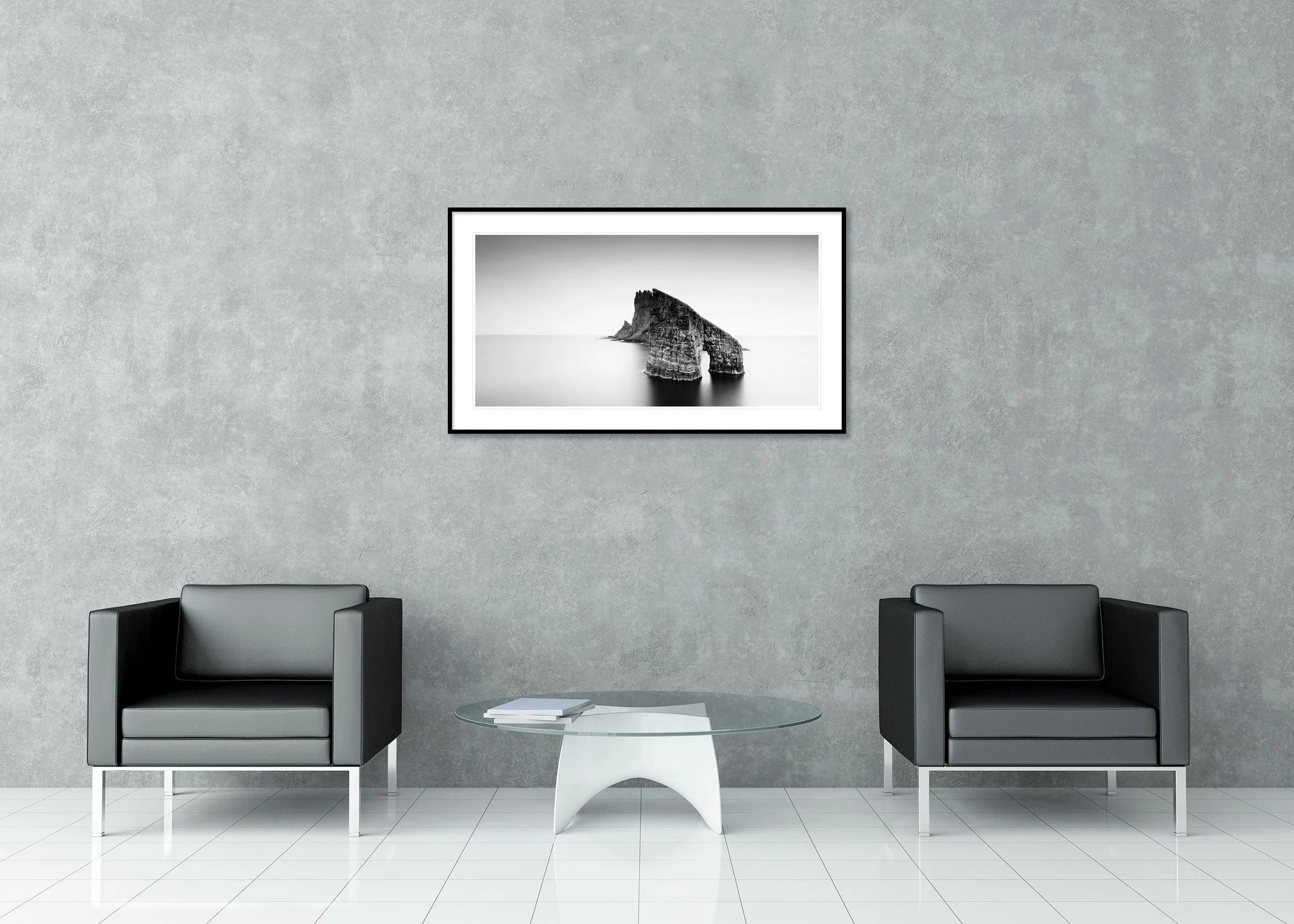 Drangarnir Sea Arch Panorama displayed in a modern interior as a black-and-white Dibond print in a black aluminium ArtBox frame by Gerald Berghammer.