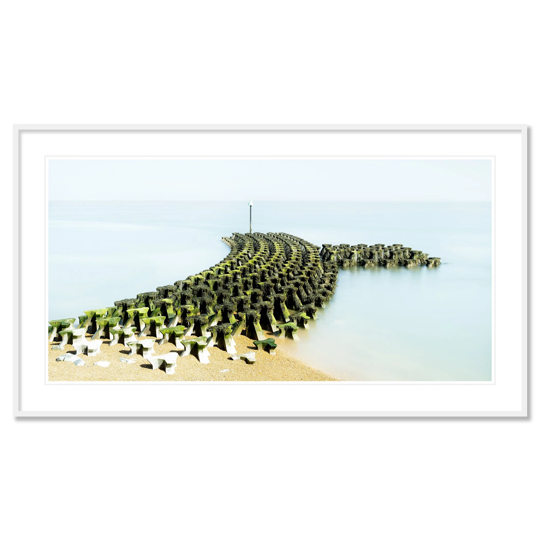 Gerald Berghammer - Color seascape panorama photography. Concrete breakwater structures on a beach extending into the water, with a pole at the end. Classic framed white