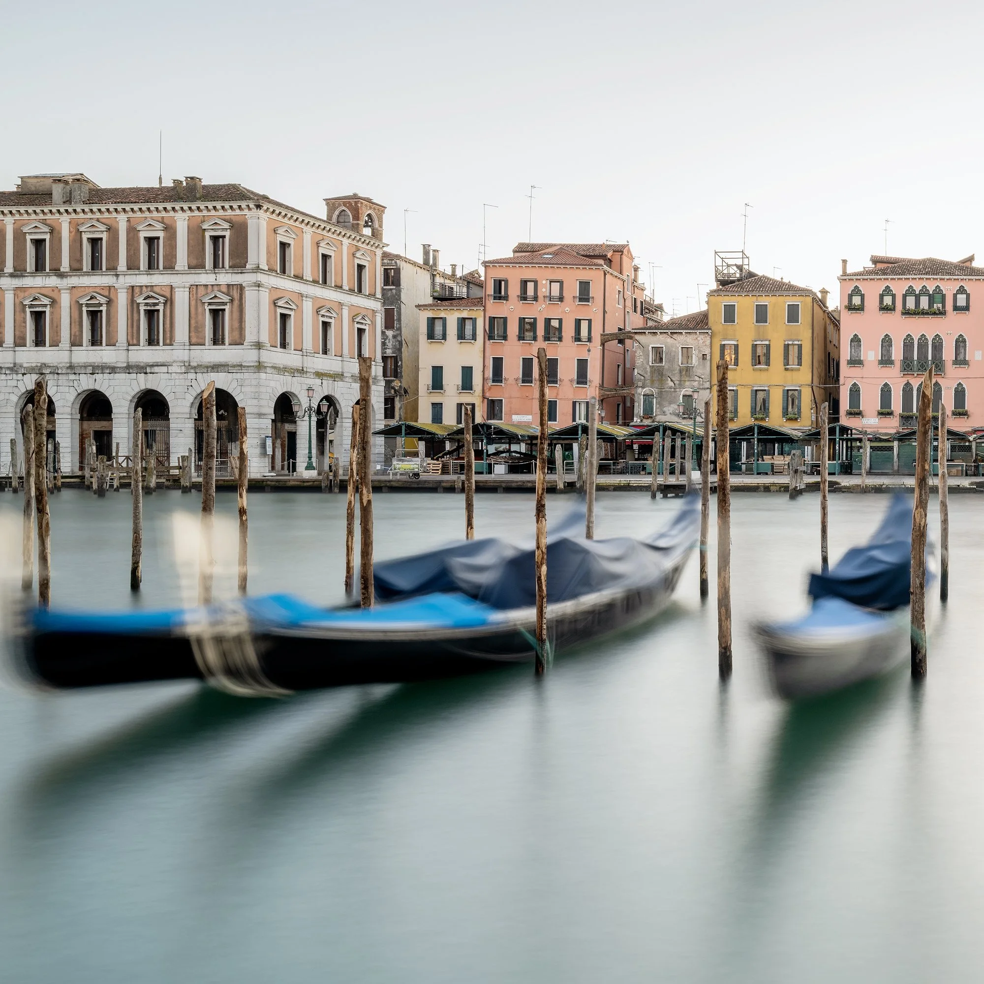 © 2025 Gerald Berghammer - Color cityscape photography. Gondolas docked along a canal in Venice, Italy, with historic buildings and the fish market in the back. Print detail 1