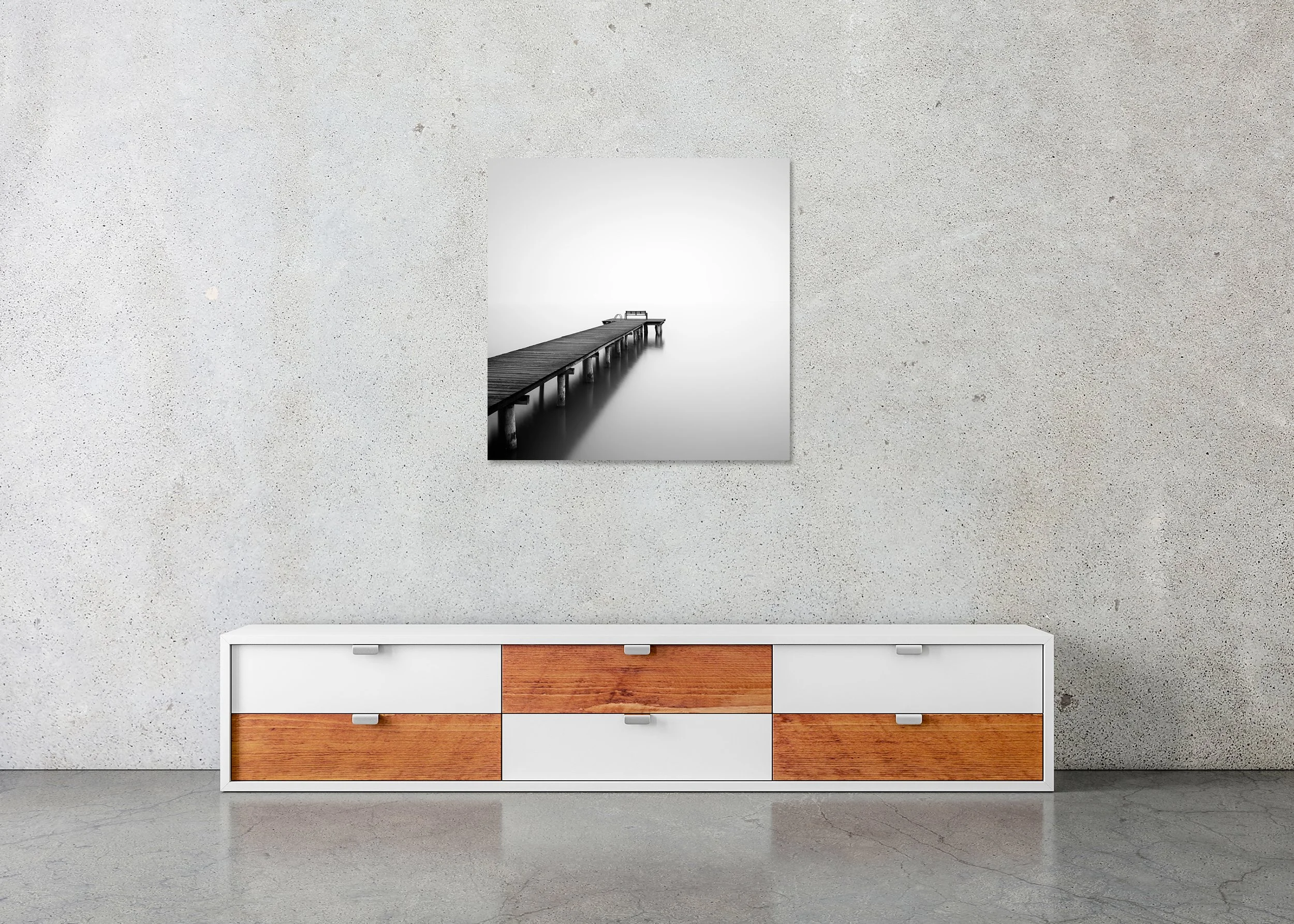 Minimalist black-and-white photo of a pier stretching into foggy, still water, with a bench at the end, on a frameless ChromaLuxe metal print.