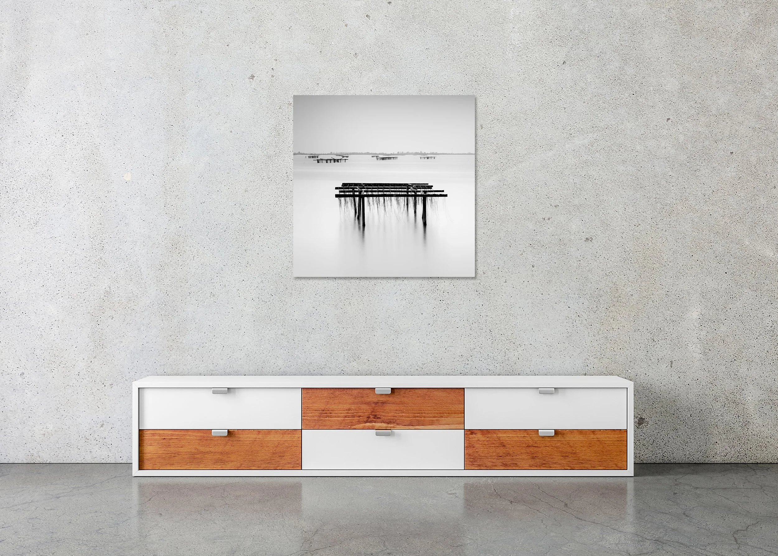 Long-exposure black and white coastal scene with wooden fishing racks in smooth water and a faint shoreline in the distance, presented as a frameless ChromaLuxe metal print.