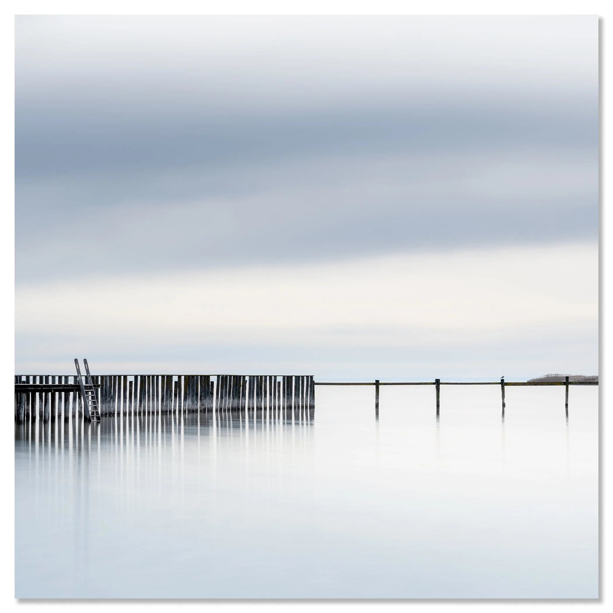 Gerald Berghammer - Color long exposure waterscape Photography. A pier extending into calm water with a ladder leaning against the side, under a cloudy sky. Chromaluxe frameless