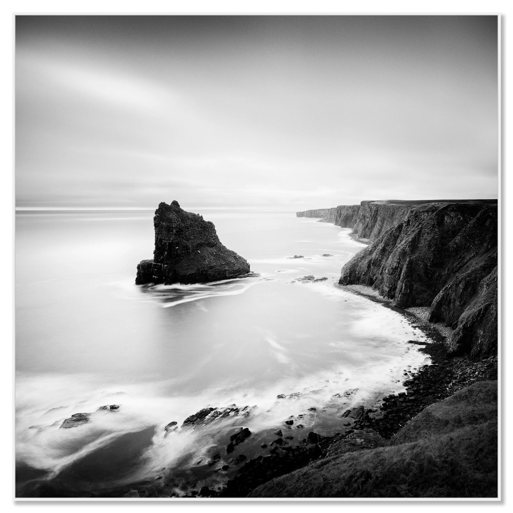 Black-and-white long-exposure seascape of Scottish cliffs and sea stack with silky water and dramatic sky – framed ArtBox white