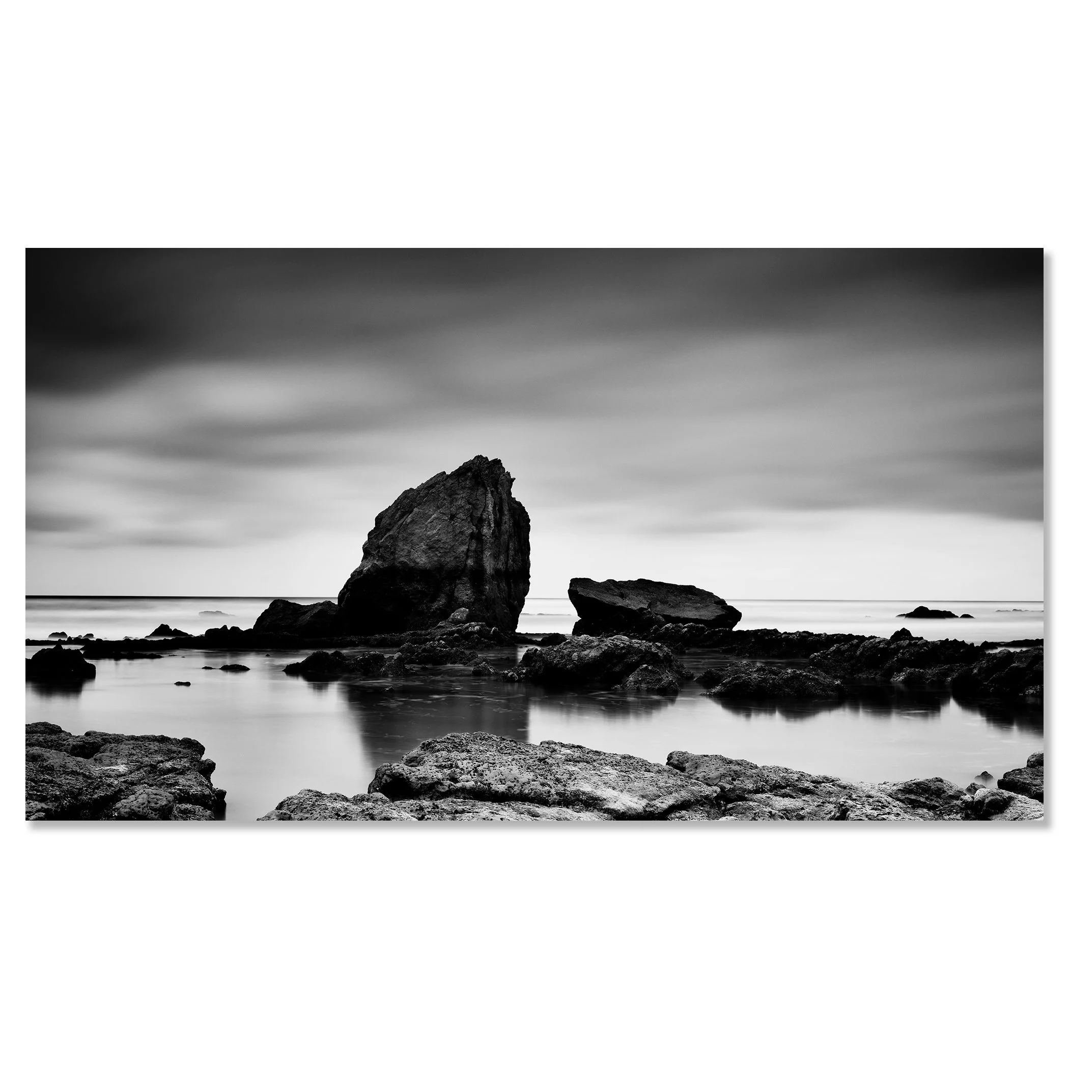Long-exposure monochrome seascape with rocky foreground, calm tidal pool and striking offshore rock formation – dibond frameless