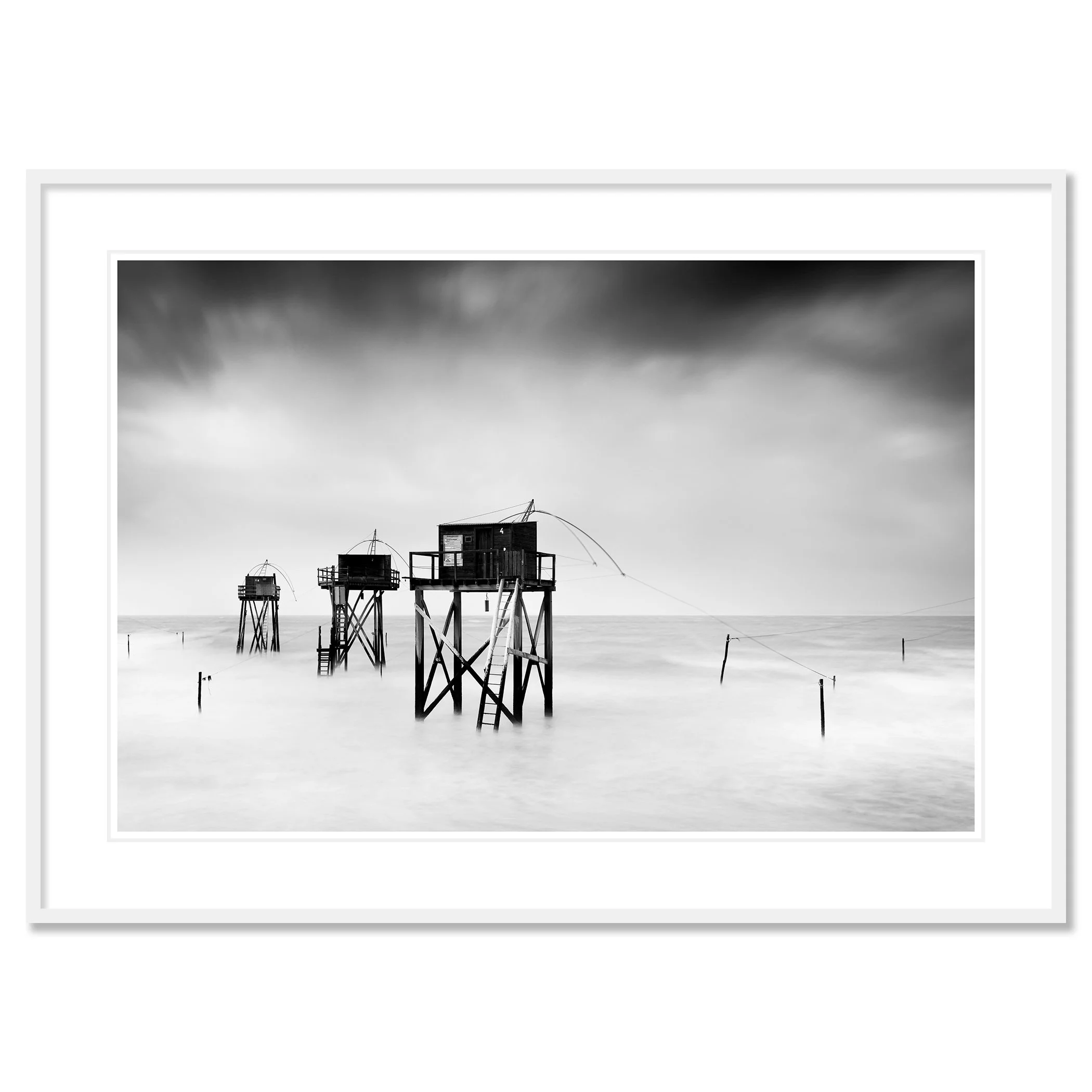 Monochrome long-exposure seascape with wooden fishing huts on stilts and misty water, ChromaLuxe framed white