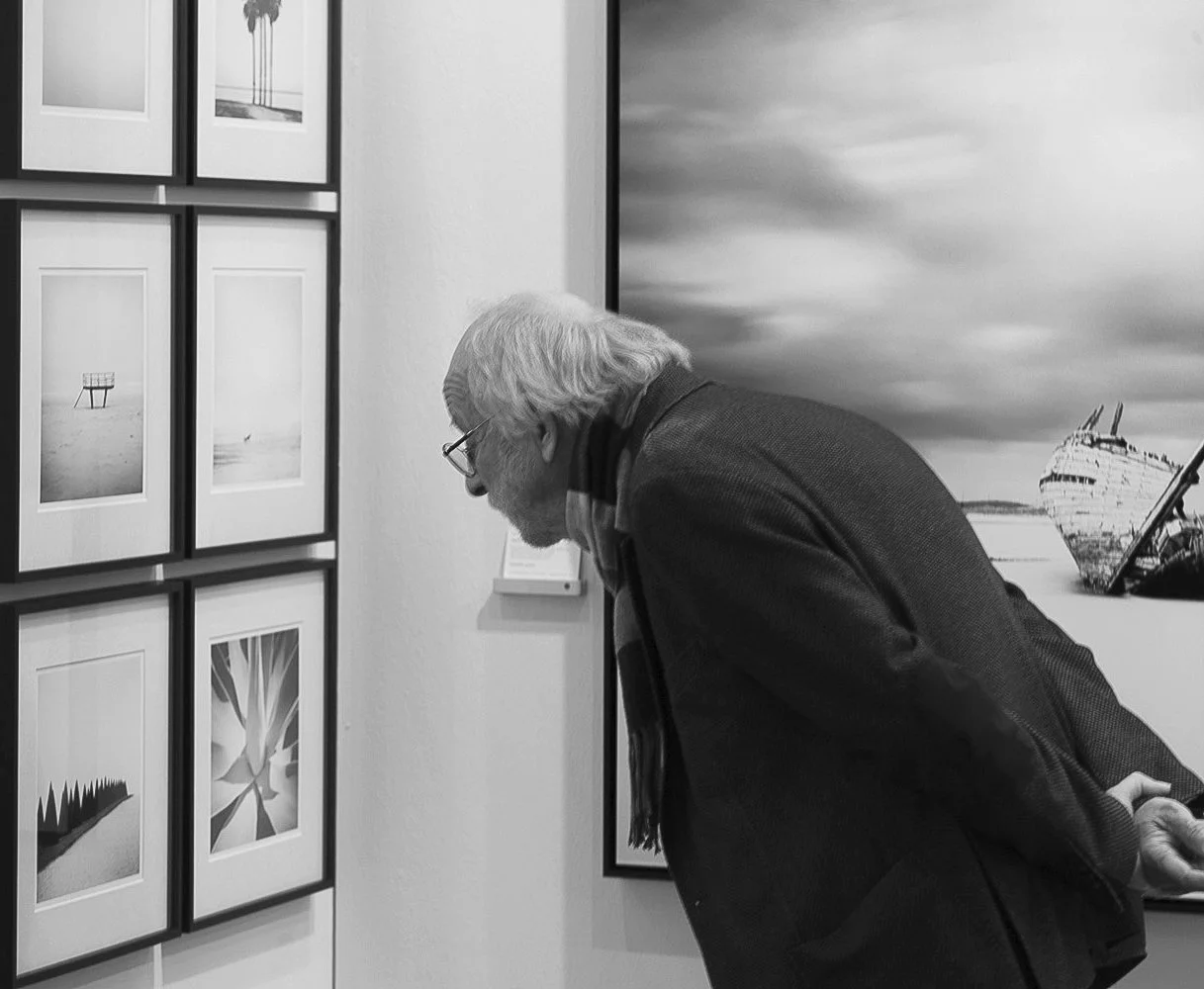 Visitor viewing black-and-white fine art photography by Gerald Berghammer at SILVERFINEART in Vienna.