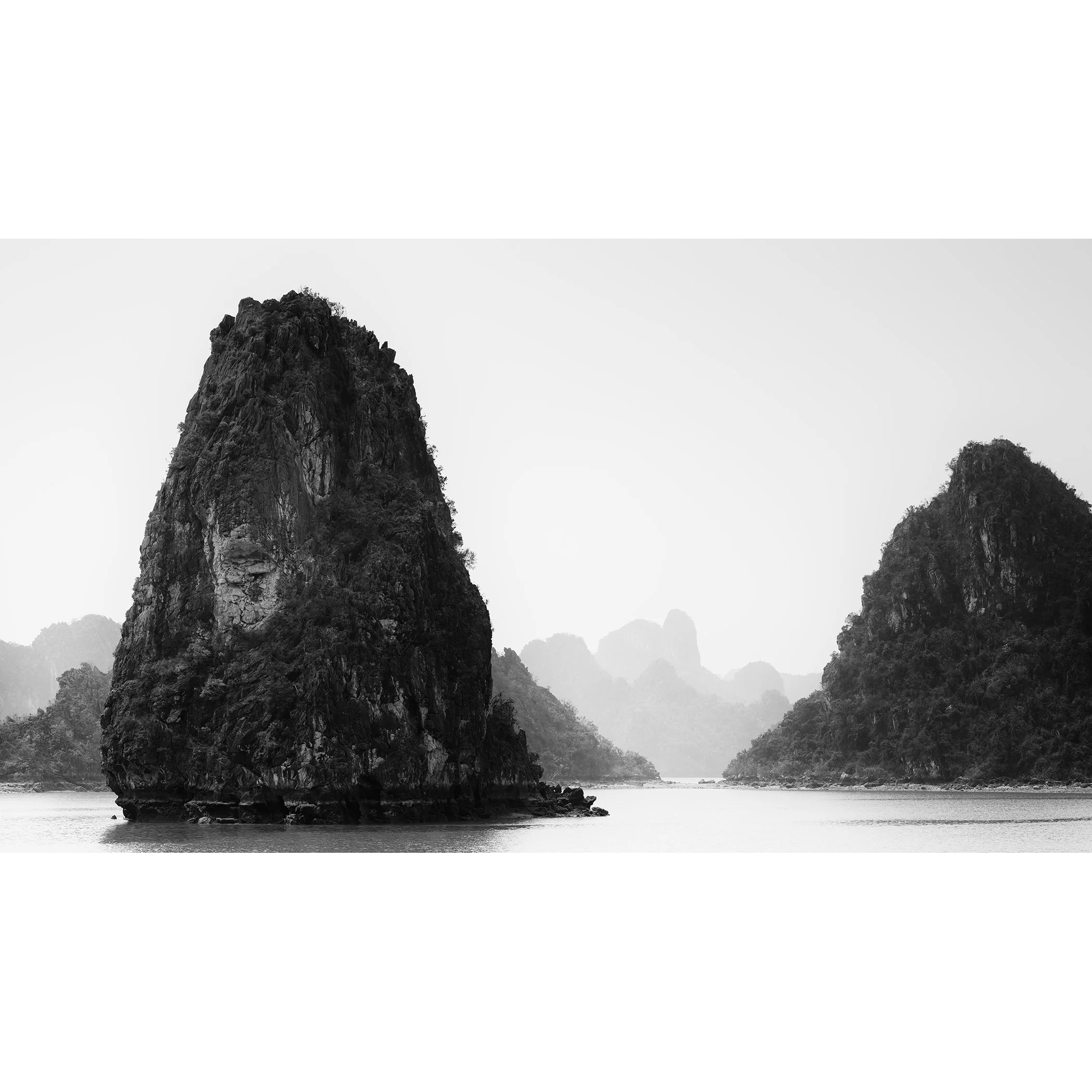 Ha Long Bay Panorama, Study 1, a minimalist black-and-white photograph of limestone karsts and calm water in Vietnam by Gerald Berghammer.